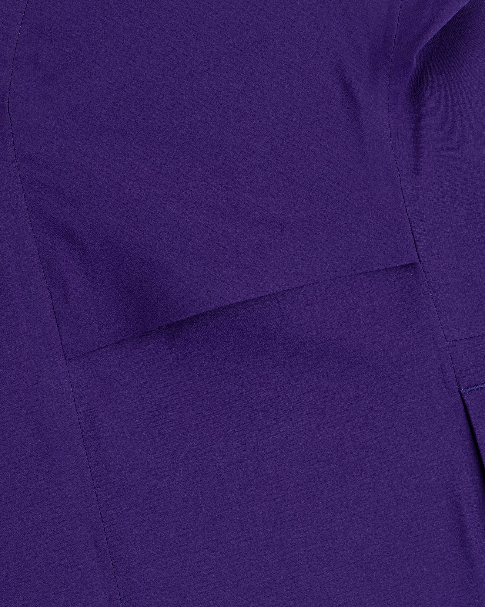 Close-up of a Lightweight GORE-TEX Shell Jacket in purple, featuring visible stitching and seam lines.