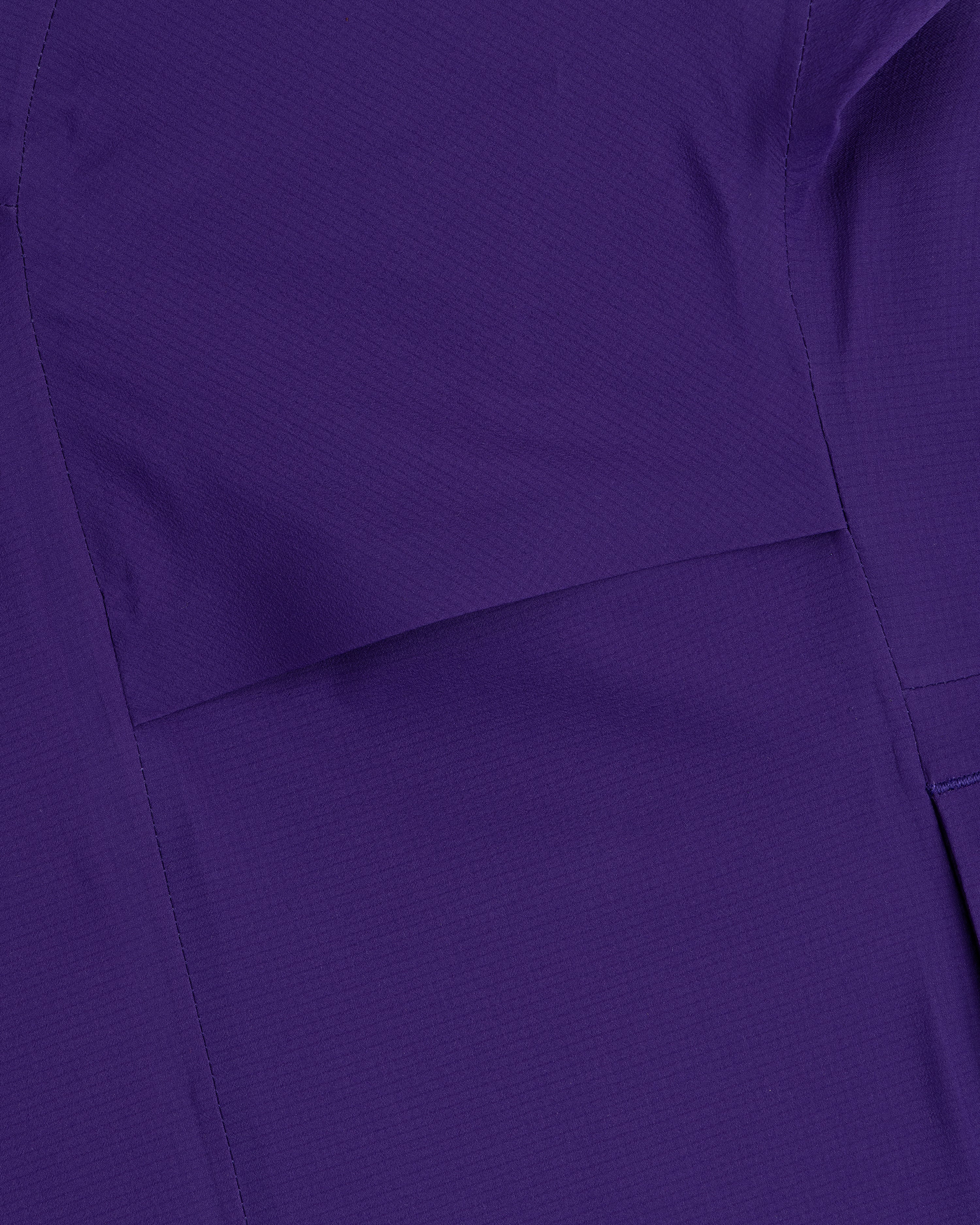 Close-up of a Lightweight GORE-TEX Shell Jacket in purple, featuring visible stitching and seam lines.