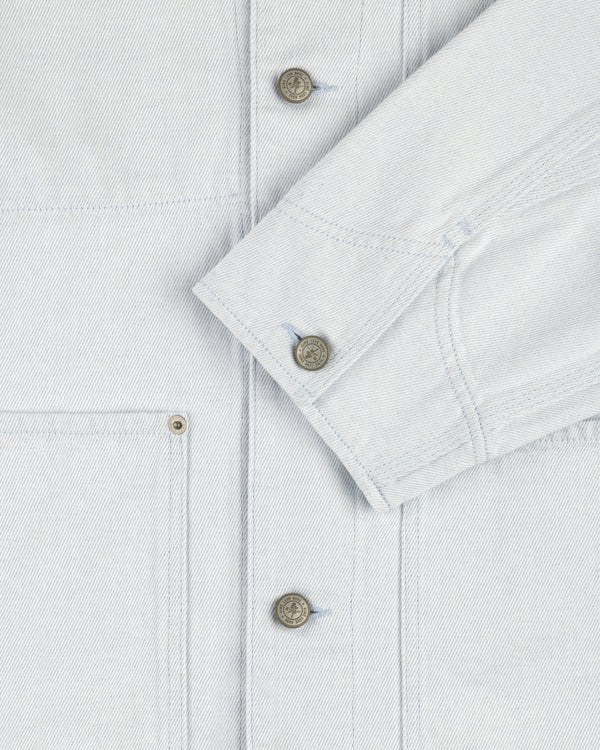 Close-up of a Denim Barn Jacket with metal buttons, visible stitching, chest pocket, and sleeve cuff.