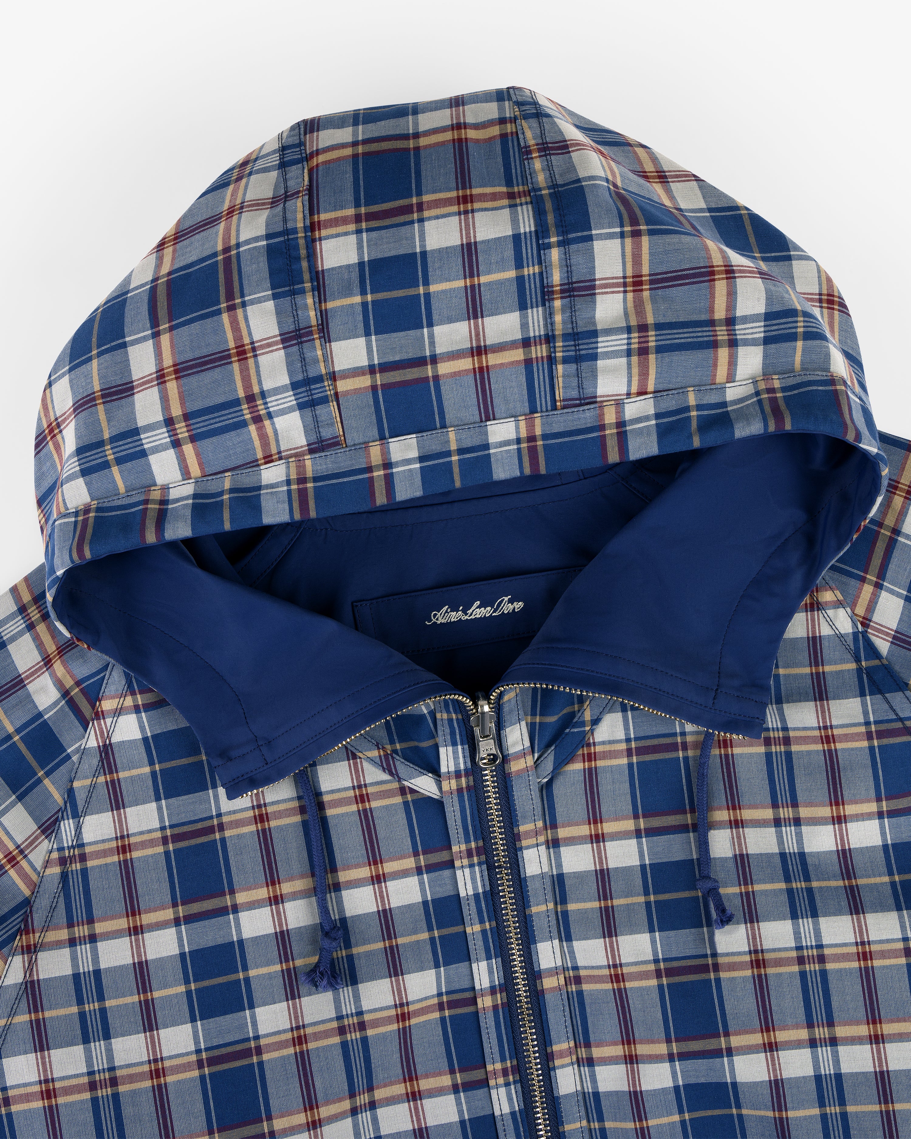 Reversible Madras Windbreaker in blue, white, and red plaid with hood, zipper, and solid blue lining, top view.