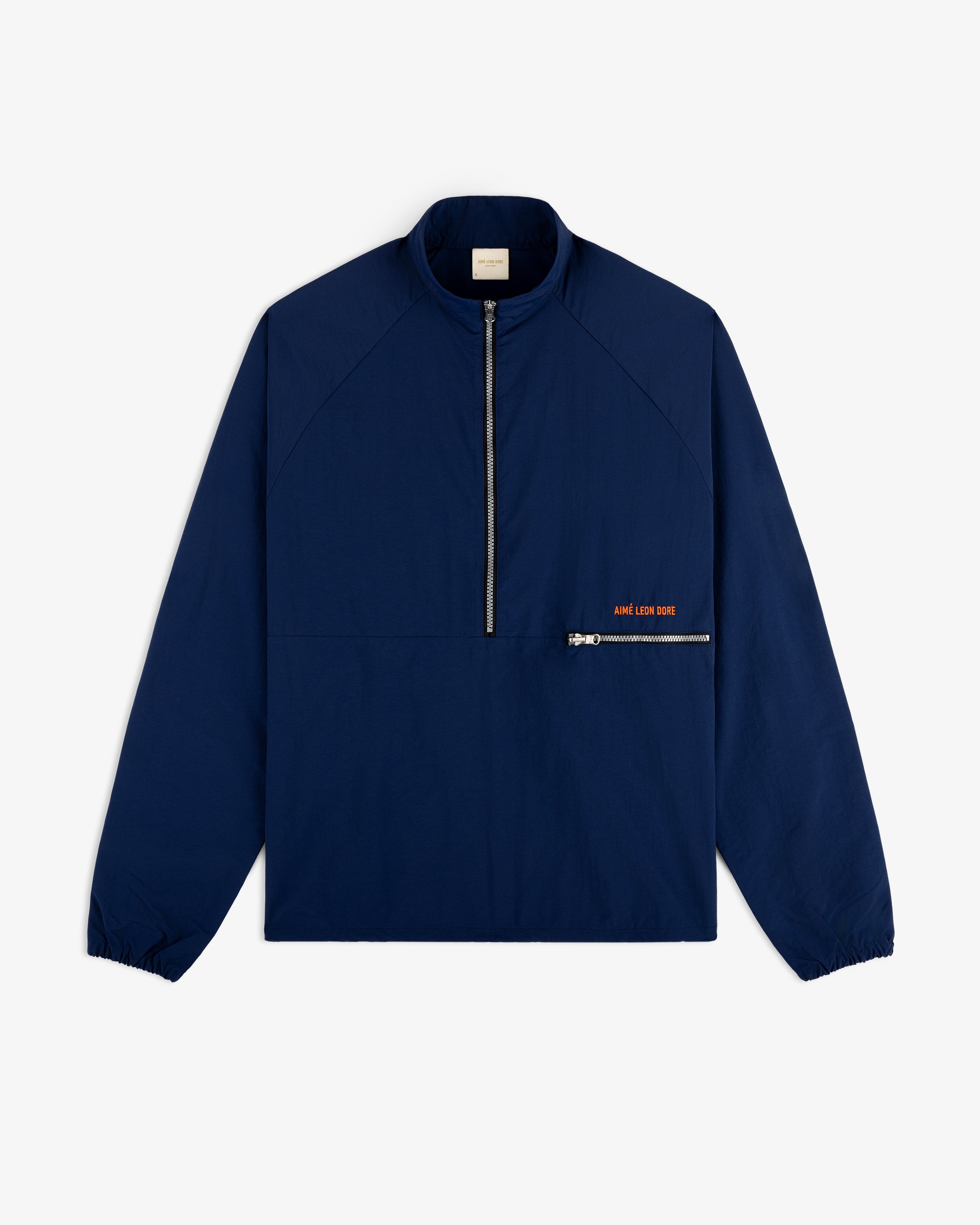 Nylon Packable Windbreaker in navy blue with half-zip front, diagonal pocket, and subtle orange text.