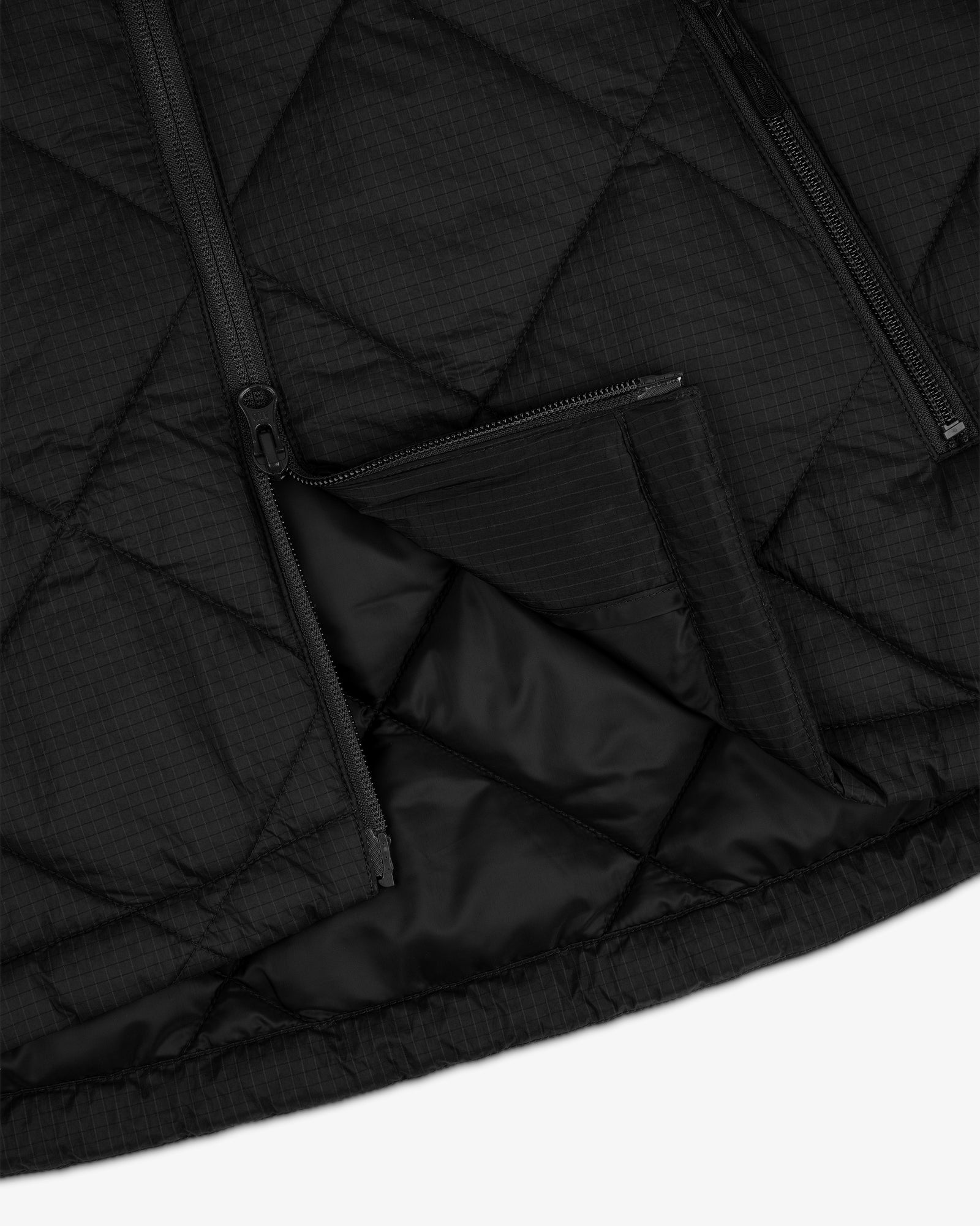 Close-up of the Nylon Quilted Unisphere Jacket with zippers and a partially opened zippered pocket.