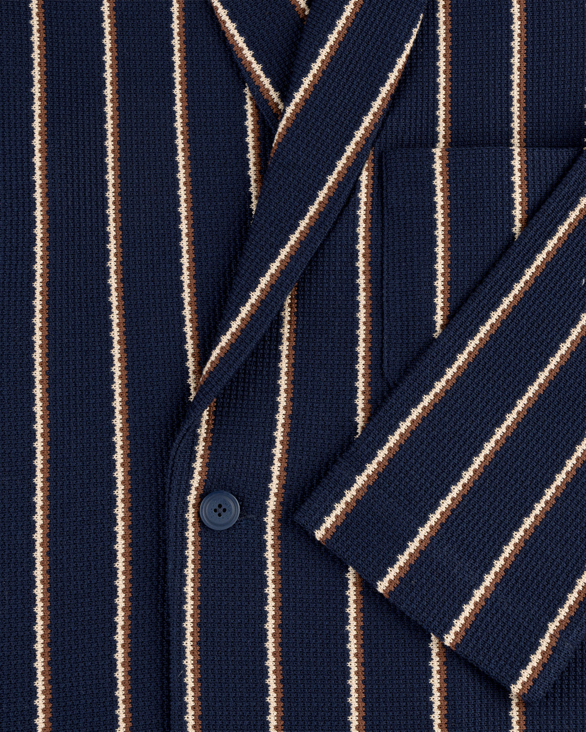 Close-up of the Striped Jacquard Shawl Collar Jacket in navy with white and brown stripes, front pocket, and button.
