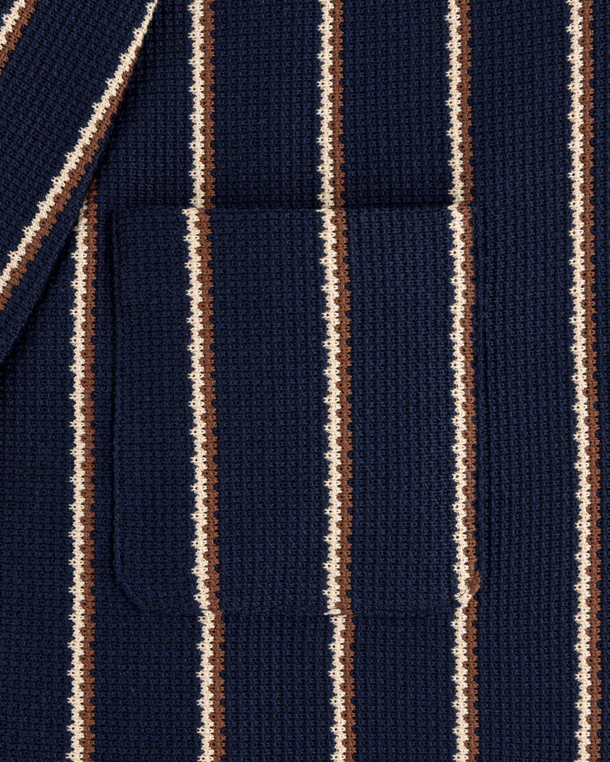 Close-up of the Striped Jacquard Shawl Collar Jacket in navy with vertical white and brown stripes and a patch pocket.