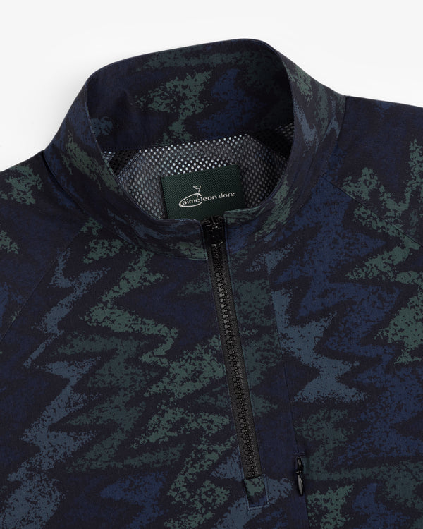 Close-up of an ALD Golf Nylon Quarter Zip Pullover with a green and blue zigzag pattern and Aimé Leon Dore collar label.