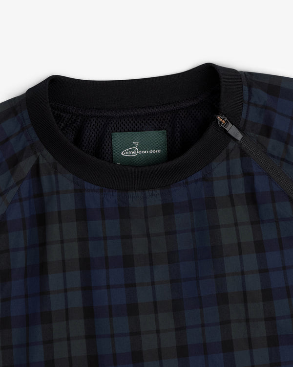 Close-up of the ALD Golf Blackwatch Pullover, featuring navy and black plaid with a black collar and Aimé Leon Dore label.