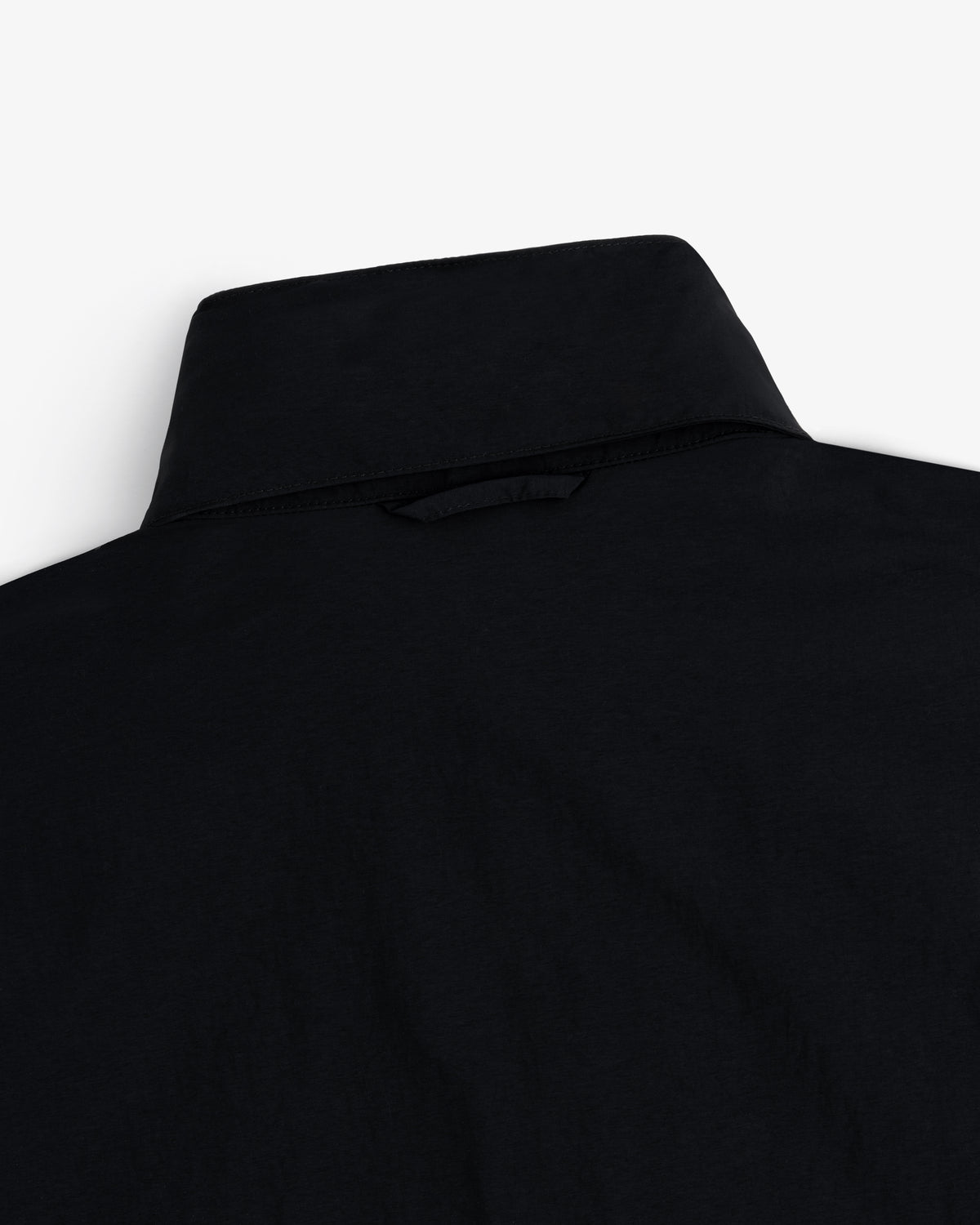 Close-up of the back of a black Nylon Track Jacket against a white background.