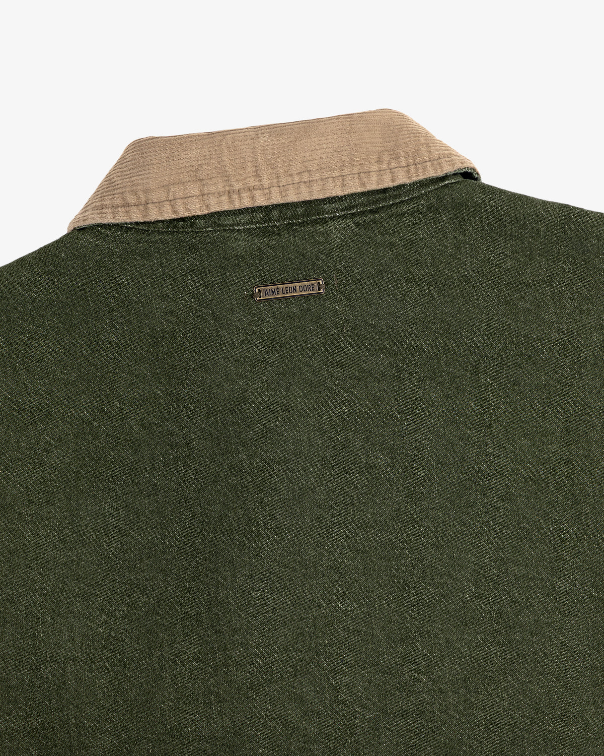 Close-up of the back of the Denim Zip Jacket featuring a beige corduroy collar and metal nameplate below it.