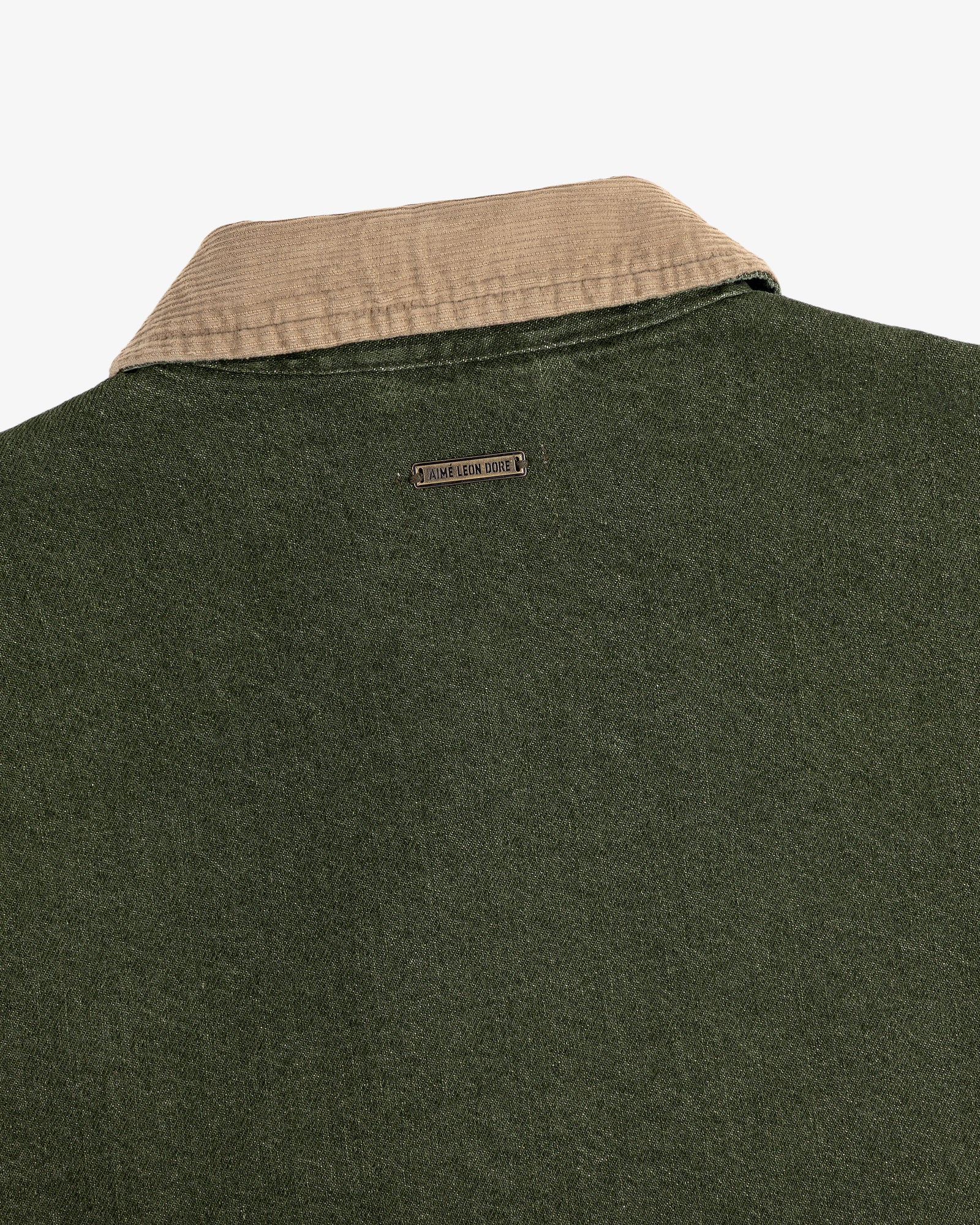 Close-up of the back of the Denim Zip Jacket featuring a beige corduroy collar and metal nameplate below it.