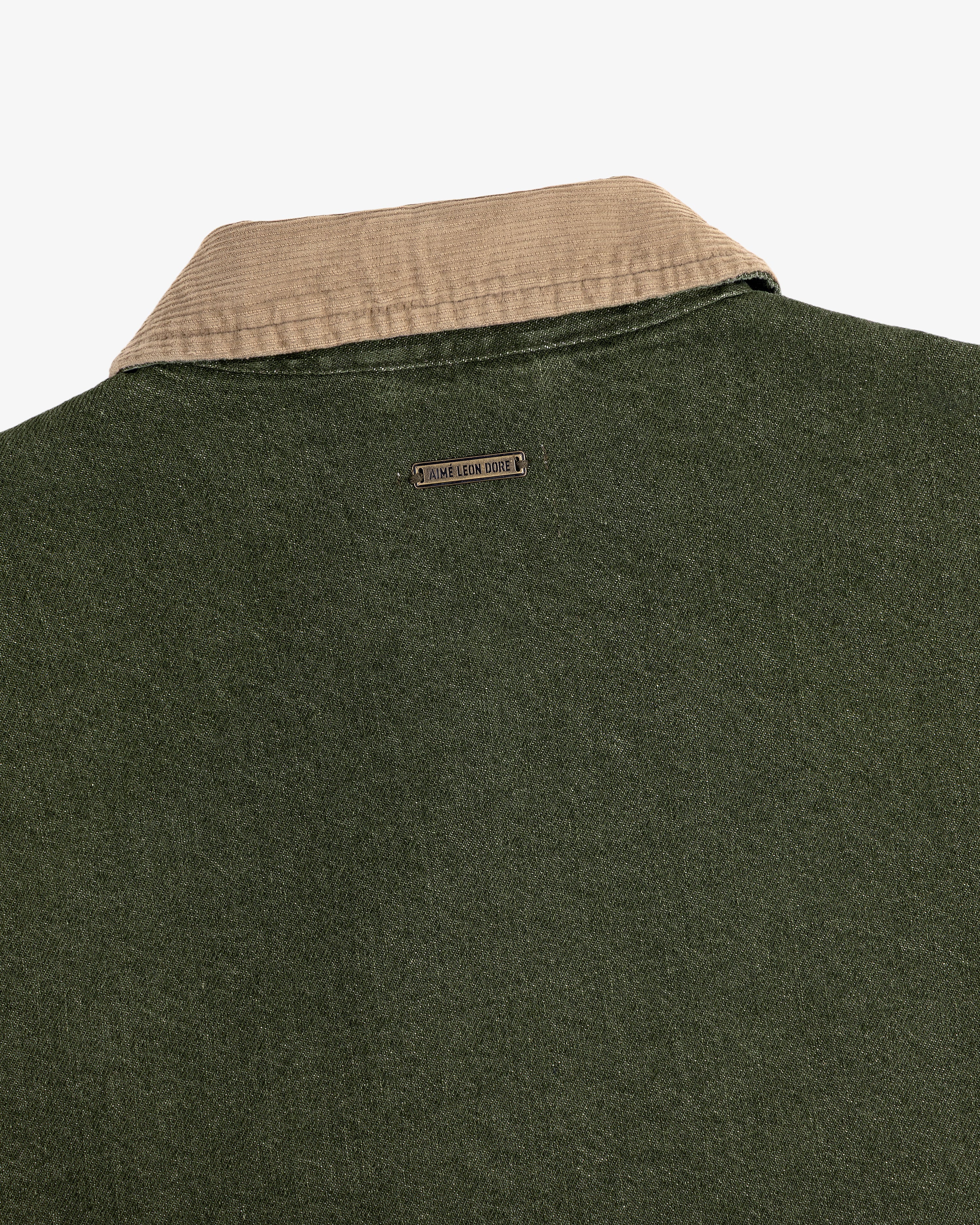 Close-up of the back of the Denim Zip Jacket featuring a beige corduroy collar and metal nameplate below it.