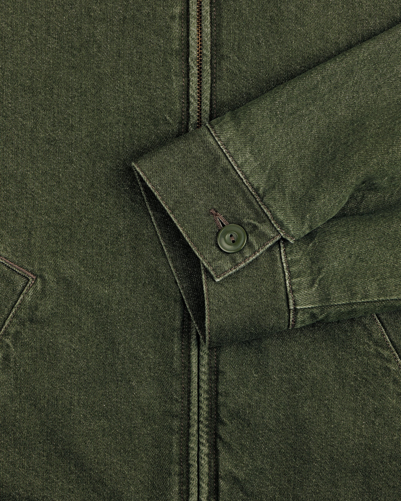Close-up of a green Denim Zip Jacket sleeve with a buttoned cuff and visible stitching against the jacket’s body.
