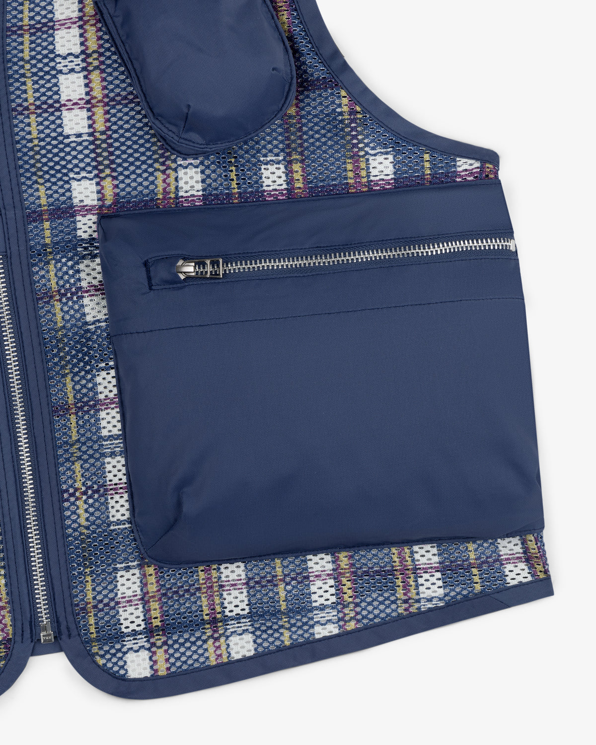 Close-up of the Nylon Madras Utility Vest with a blue finish, large zippered pocket, and plaid mesh lining underneath.