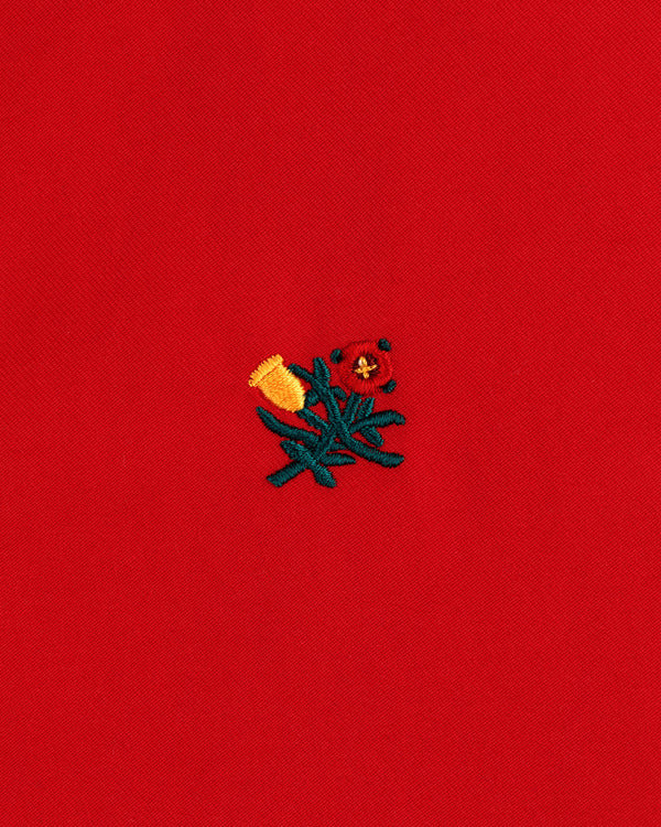 Small yellow and red embroidered flowers with green stems adorn the Crest Casual Jacket’s bright red fabric.