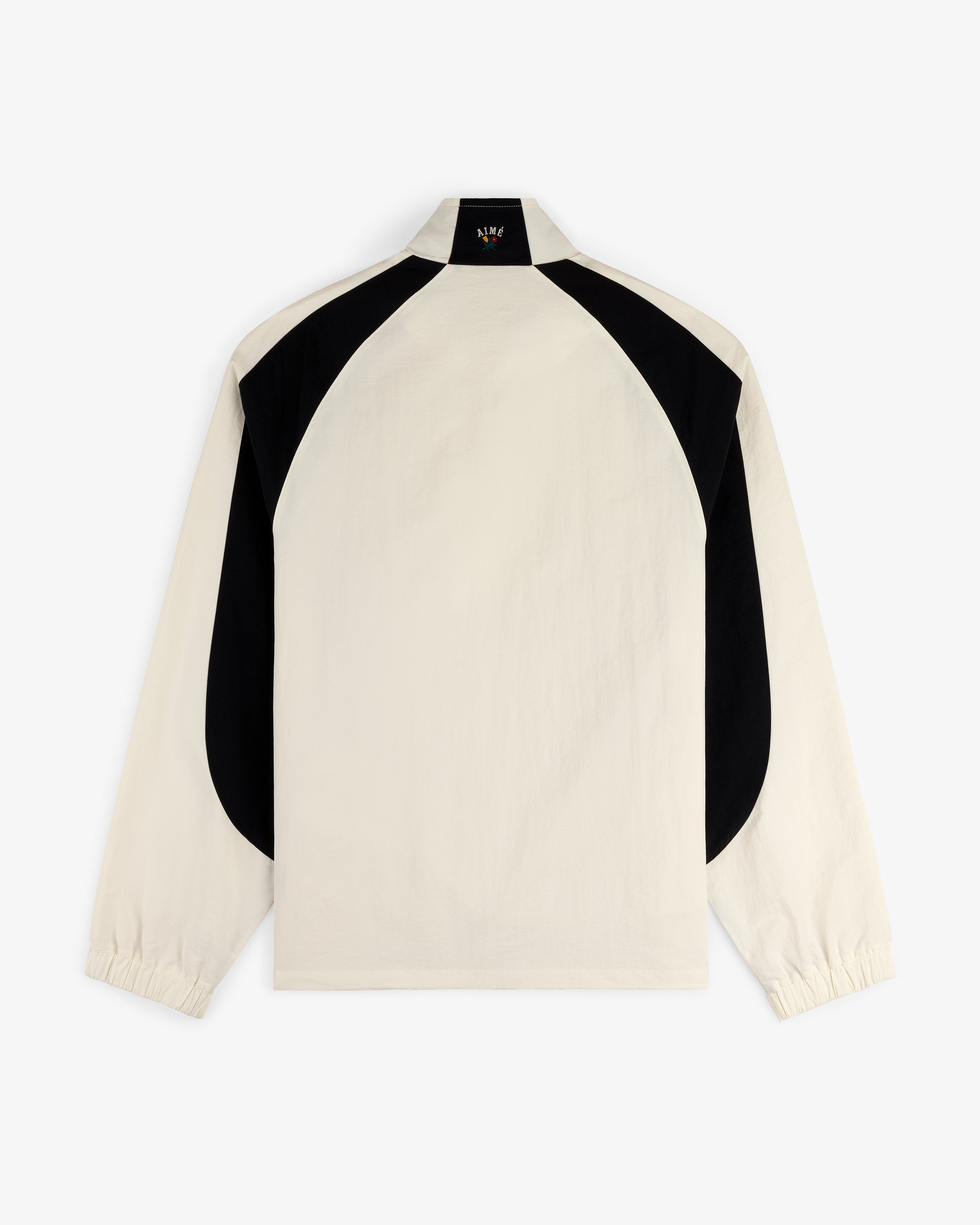 Crest Nylon Half-Zip Pullover in beige with black curved back panels and elastic cuffs, shown on white background.