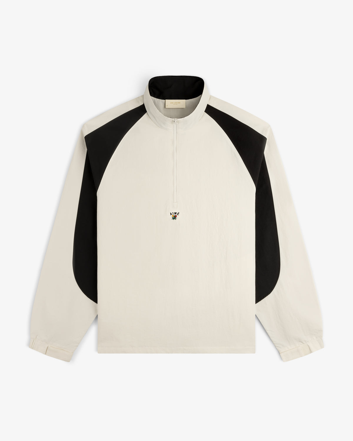 Crest Nylon Half-Zip Pullover in ivory with black shoulder panels and a small embroidered bee on the chest.