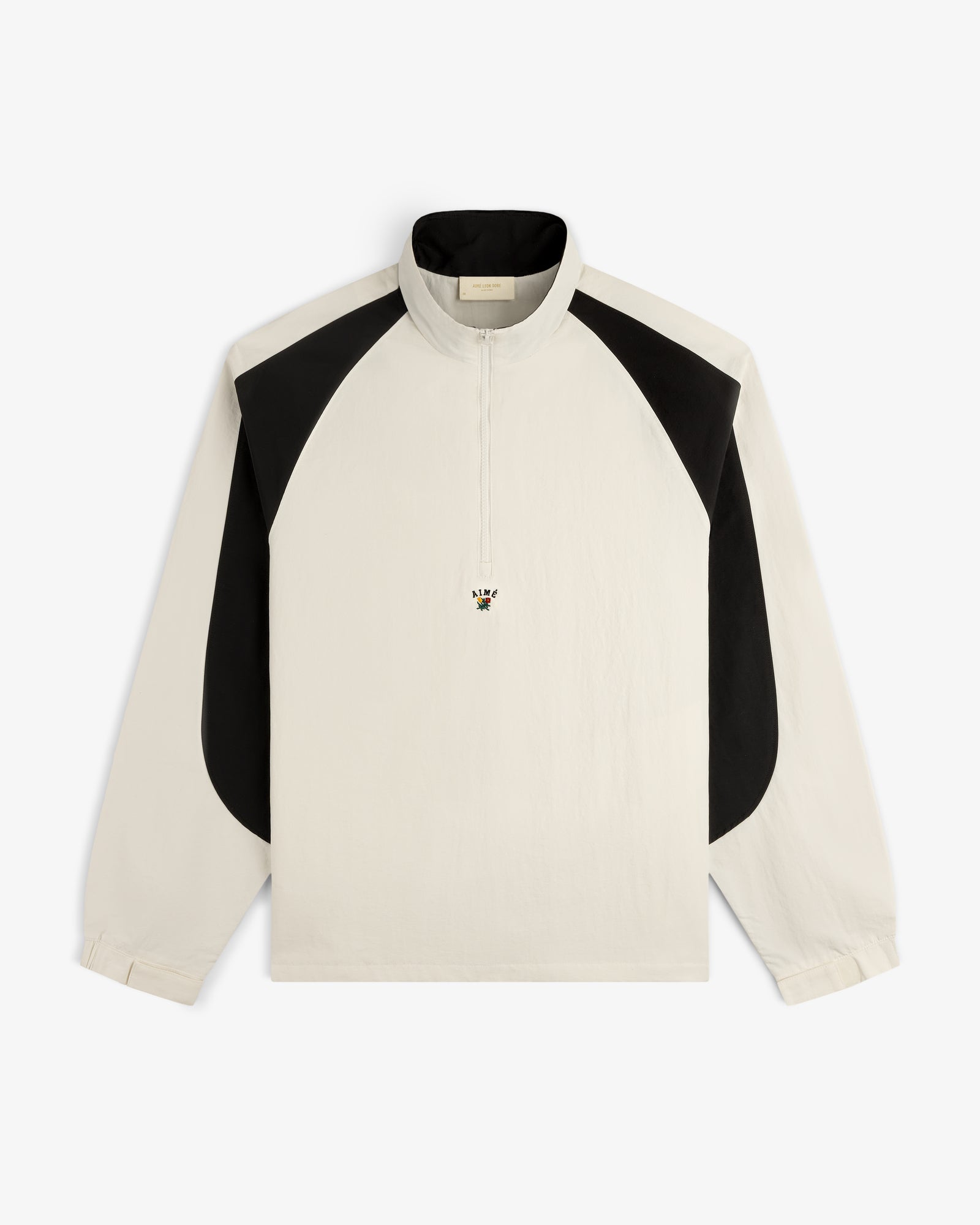 Crest Nylon Half-Zip Pullover in ivory with black shoulder panels and a small embroidered bee on the chest.
