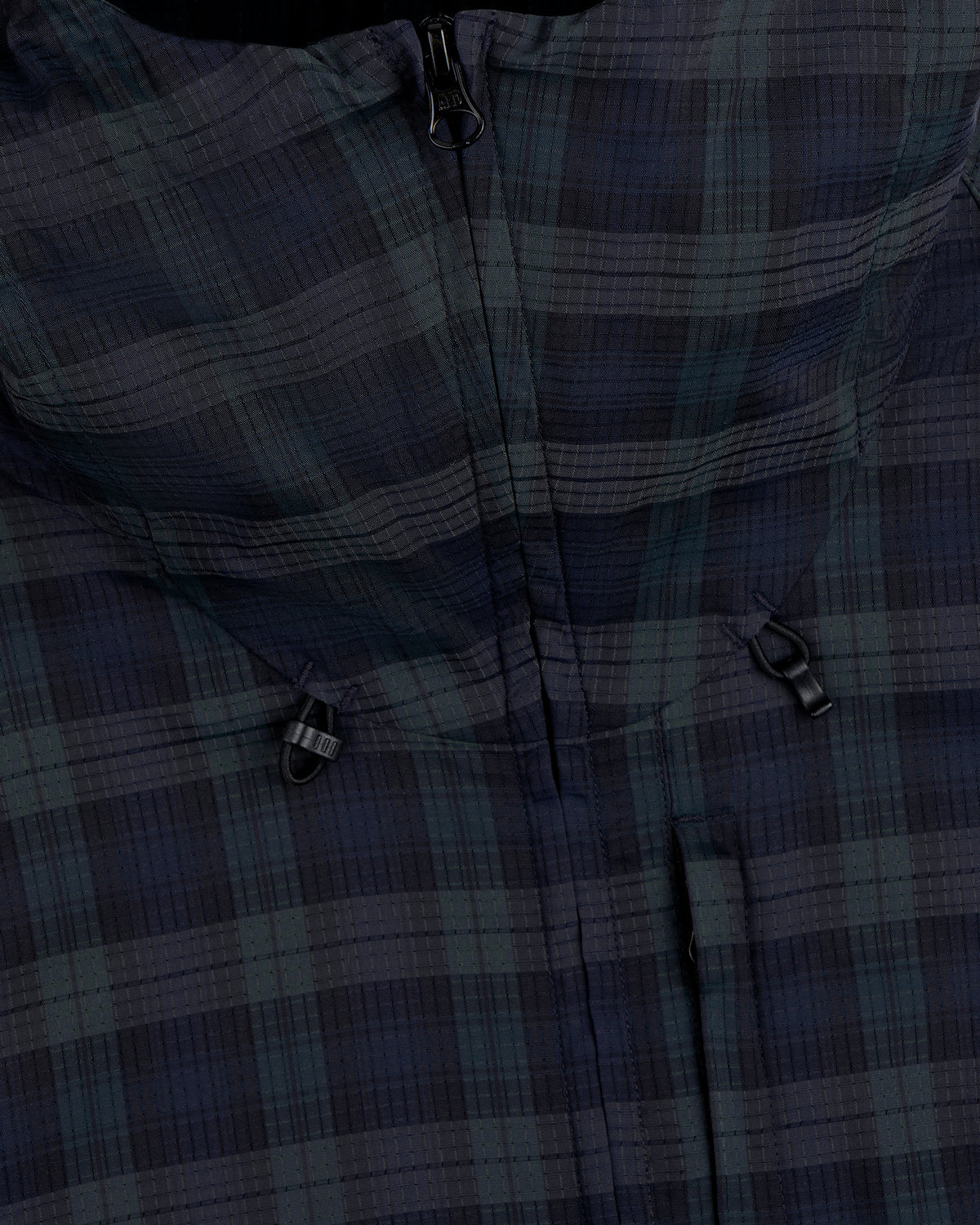 Close-up of the ALD Golf Lightweight Tips Windbreaker featuring a plaid pattern, zipper, and two black toggle adjusters.