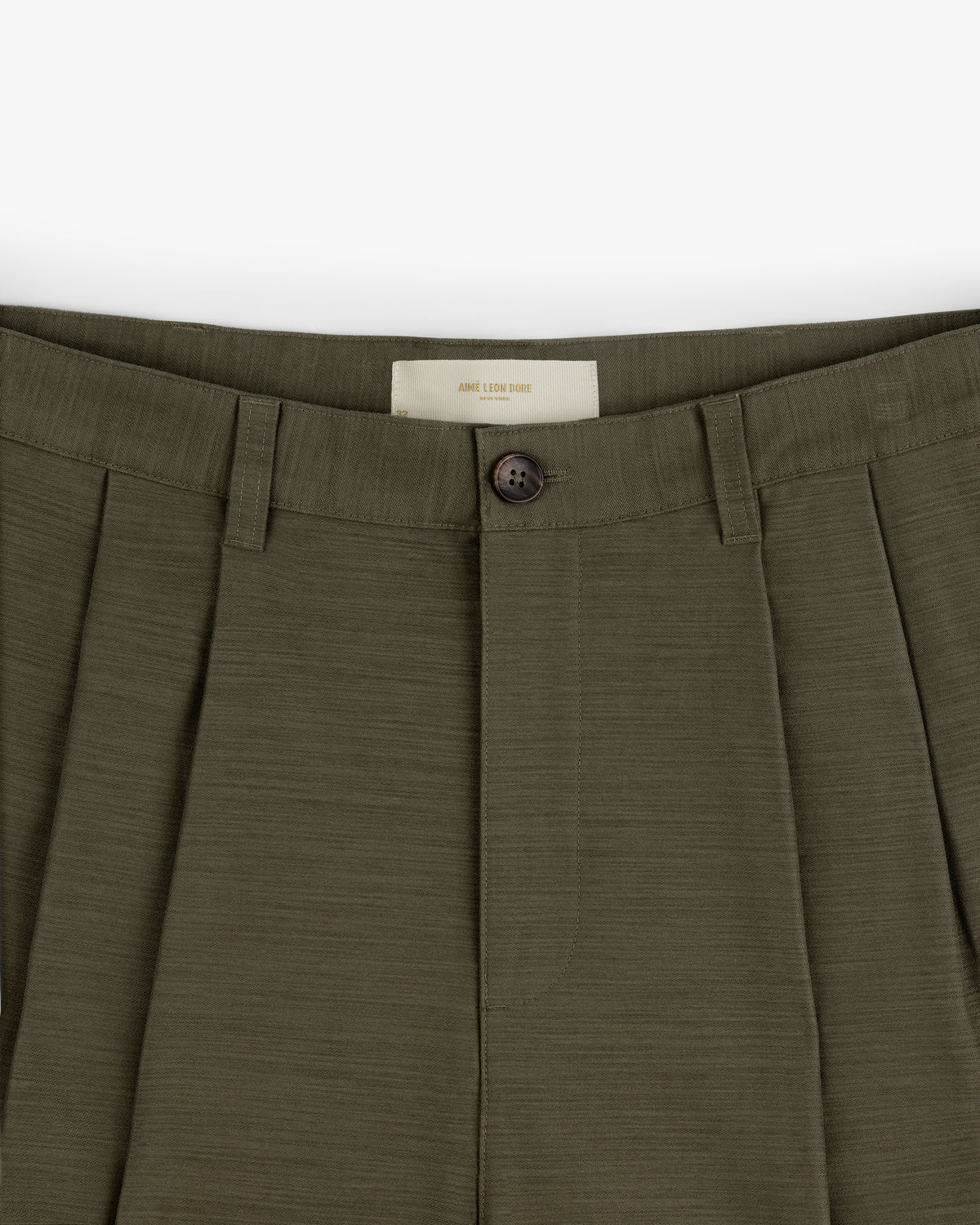 Close-up of Double Pleated Pant in olive green, featuring button closure and belt loops.