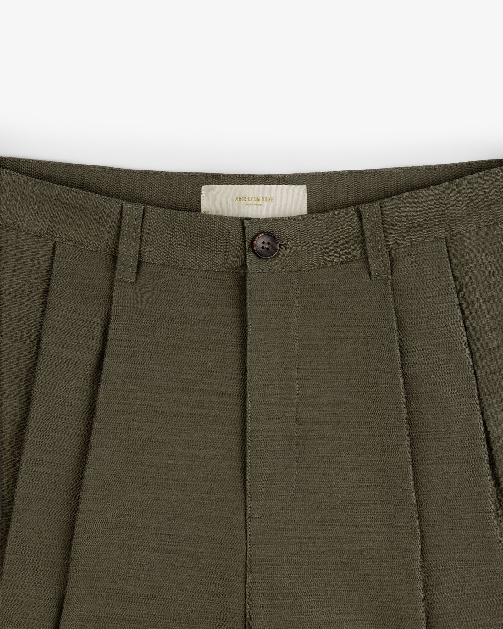 Close-up of Double Pleated Pant in olive green, featuring button closure and belt loops.