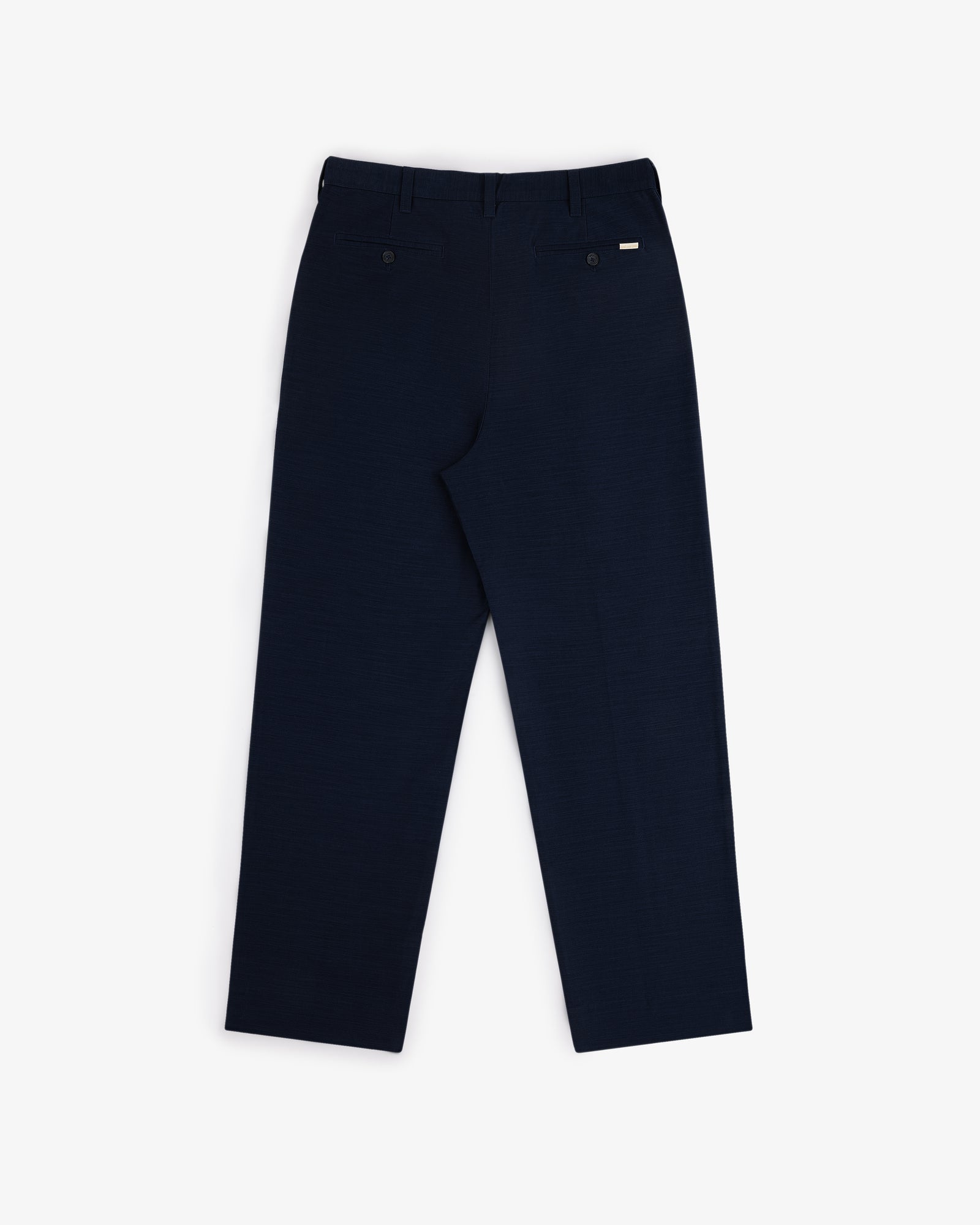 Back view of Double Pleated Pant in dark navy with two back pockets and belt loops, laid flat on white background.