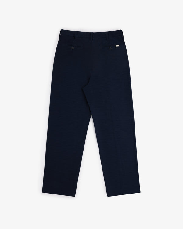 Back view of Double Pleated Pant in dark navy with two back pockets and belt loops, laid flat on white background.