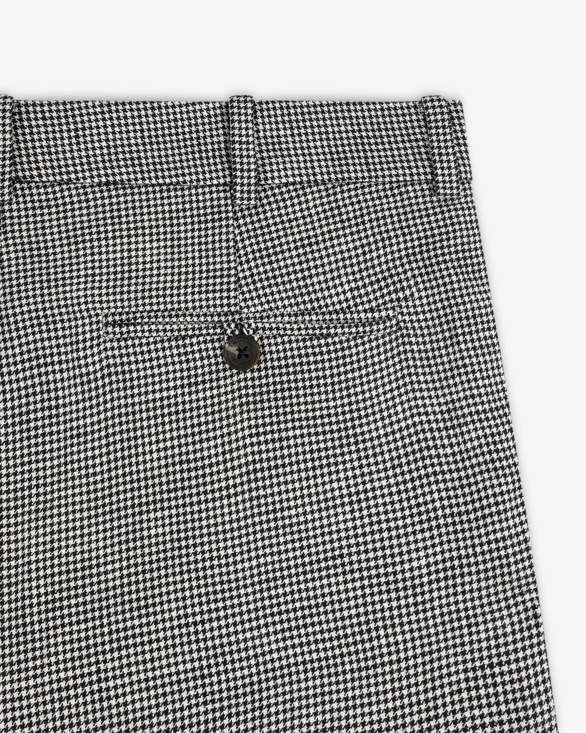 Close-up of Houndstooth Pleated Trouser in black and white, featuring a back pocket and black button.