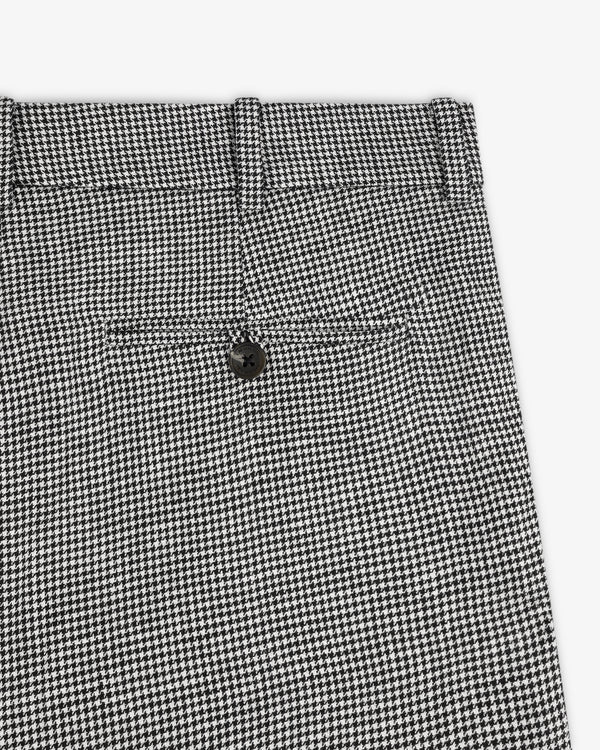 Close-up of Houndstooth Pleated Trouser in black and white, featuring a back pocket and black button.