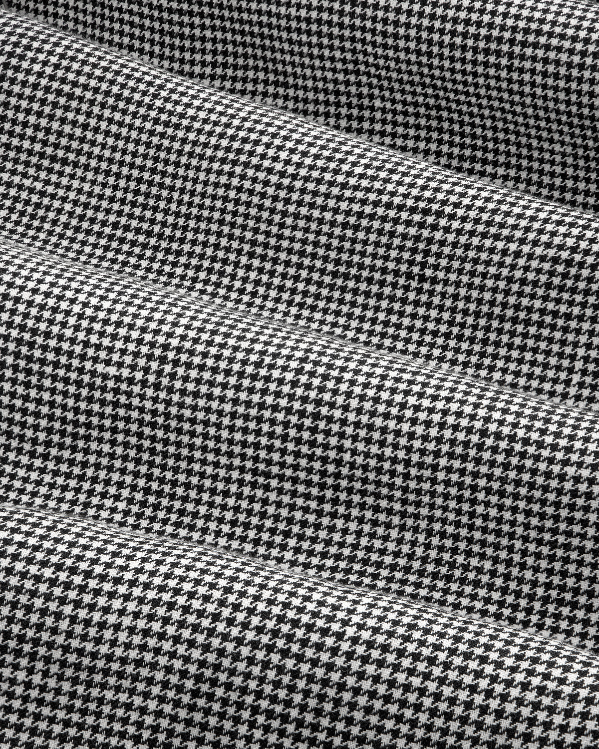 Black and white houndstooth Pleated Trouser with gentle folds and a soft, textured appearance.