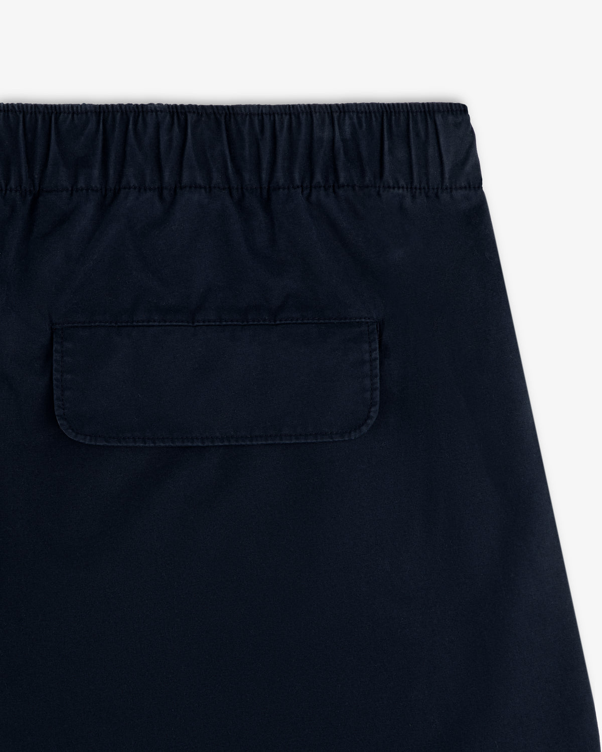 Close-up of the back of Washed Cotton Windbreaker Pant in navy with elastic waistband and flap pocket.