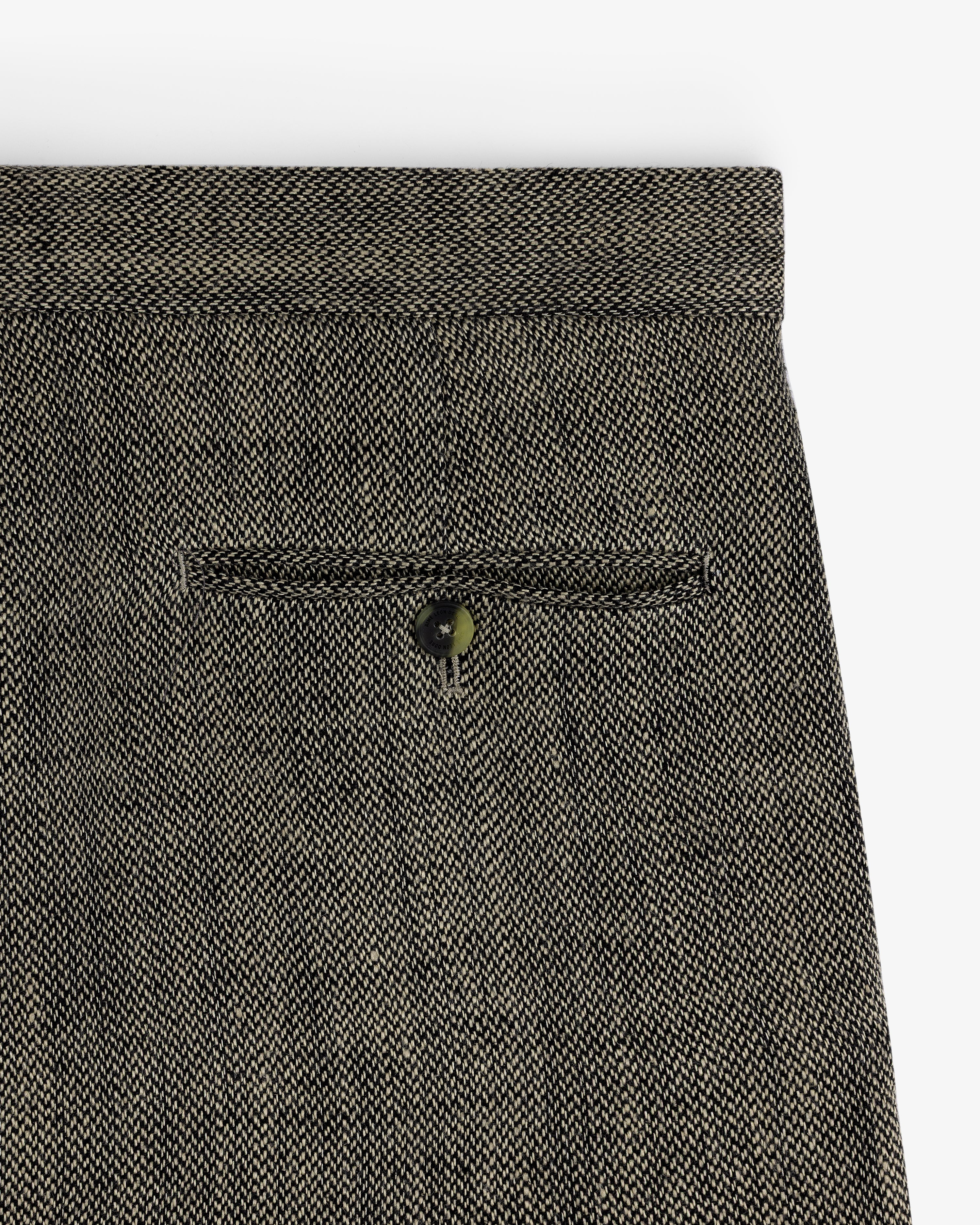 Close-up of the back pocket on Yarn Dyed Linen Suit Trouser in gray with a single button closure.