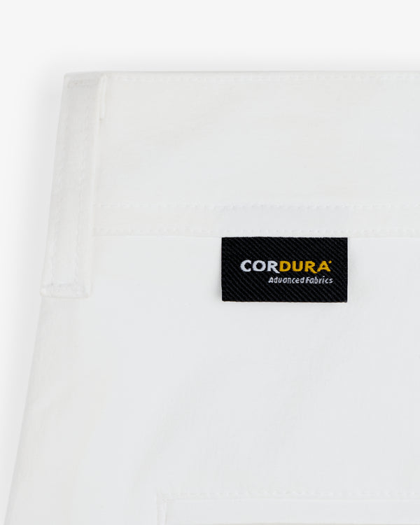 Close-up of ALD Golf Cordura Double Pleated Pant's white fabric with a black CORDURA Advanced Fabrics label stitched on.