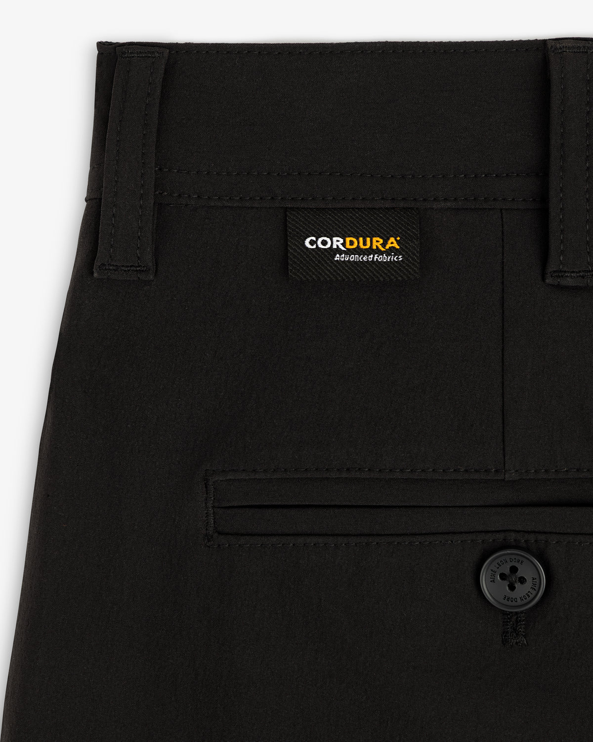 Close-up of ALD Golf Cordura Double Pleated Pant with a buttoned back pocket and Cordura label above it.