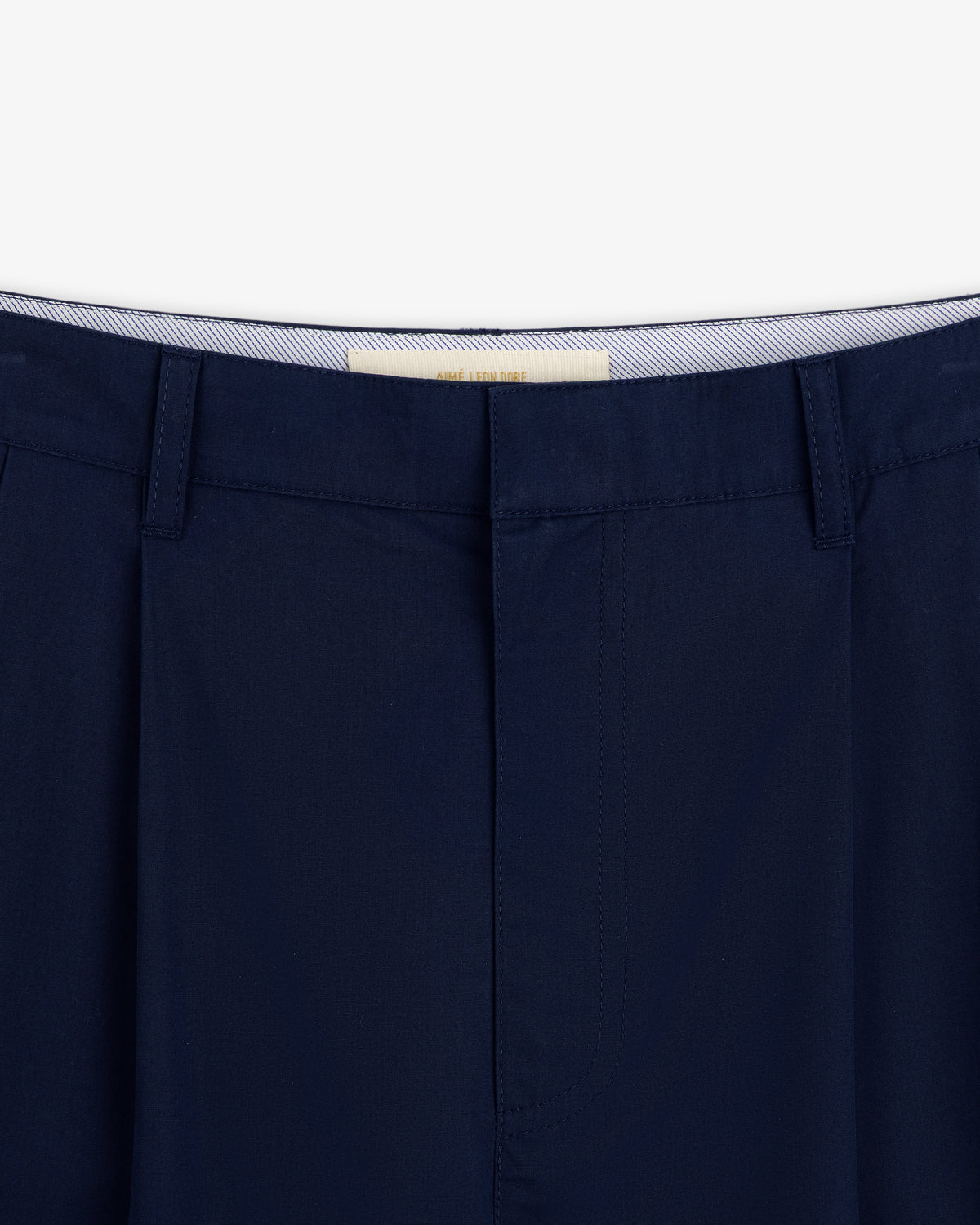 Close-up of the waistband and top of Lightweighted Pleated Cotton Trouser in dark blue with belt loops and concealed closure.