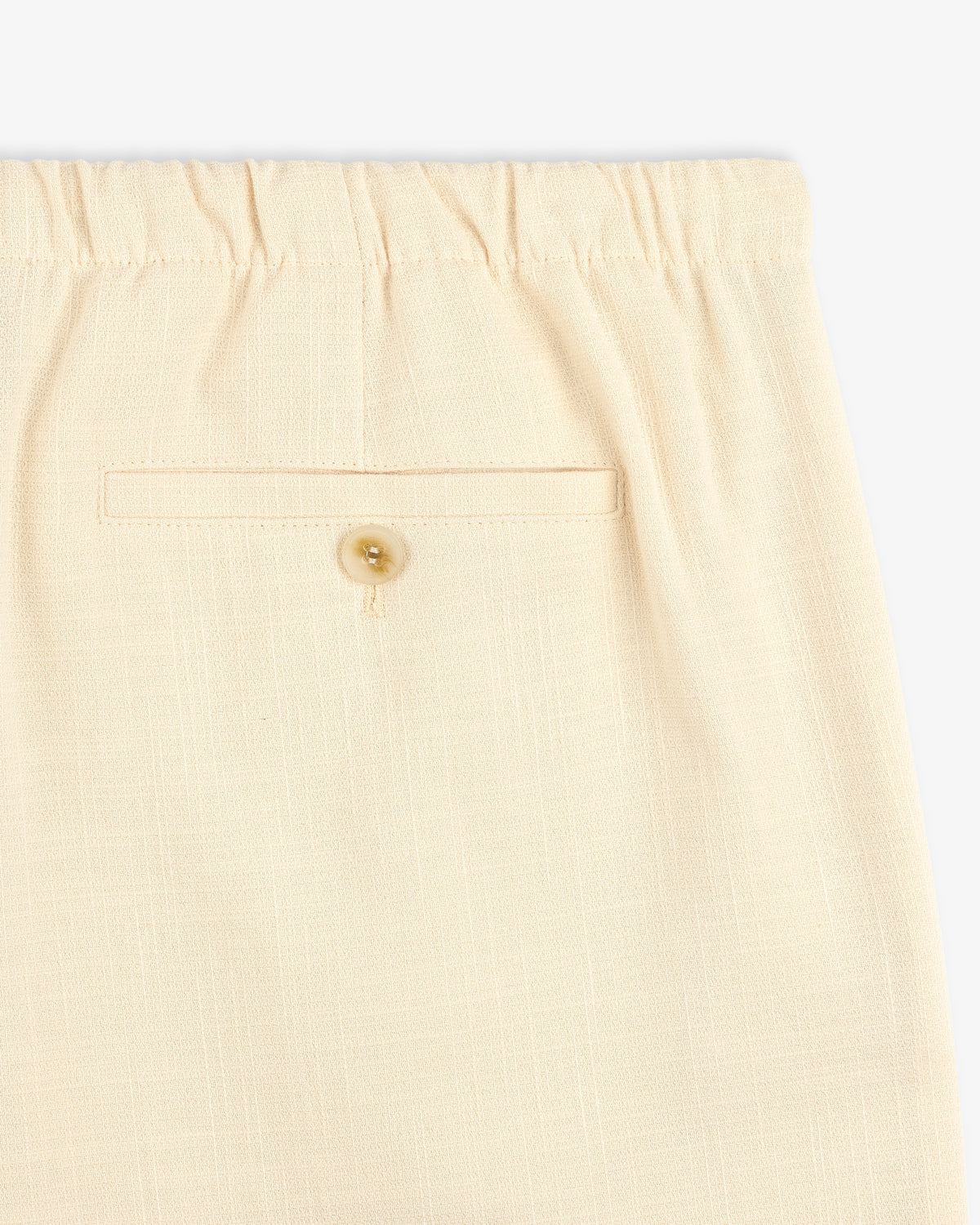 Close-up of Drawstring Cotton Blend Suit Trouser in beige, featuring an elastic waistband and a buttoned back pocket.