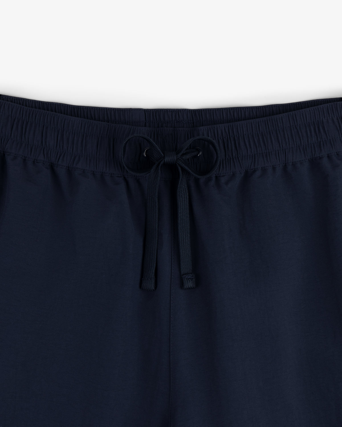 Close-up of Crest Nylon Track Pant in navy blue with an elastic waistband and drawstring, shown against a plain background.