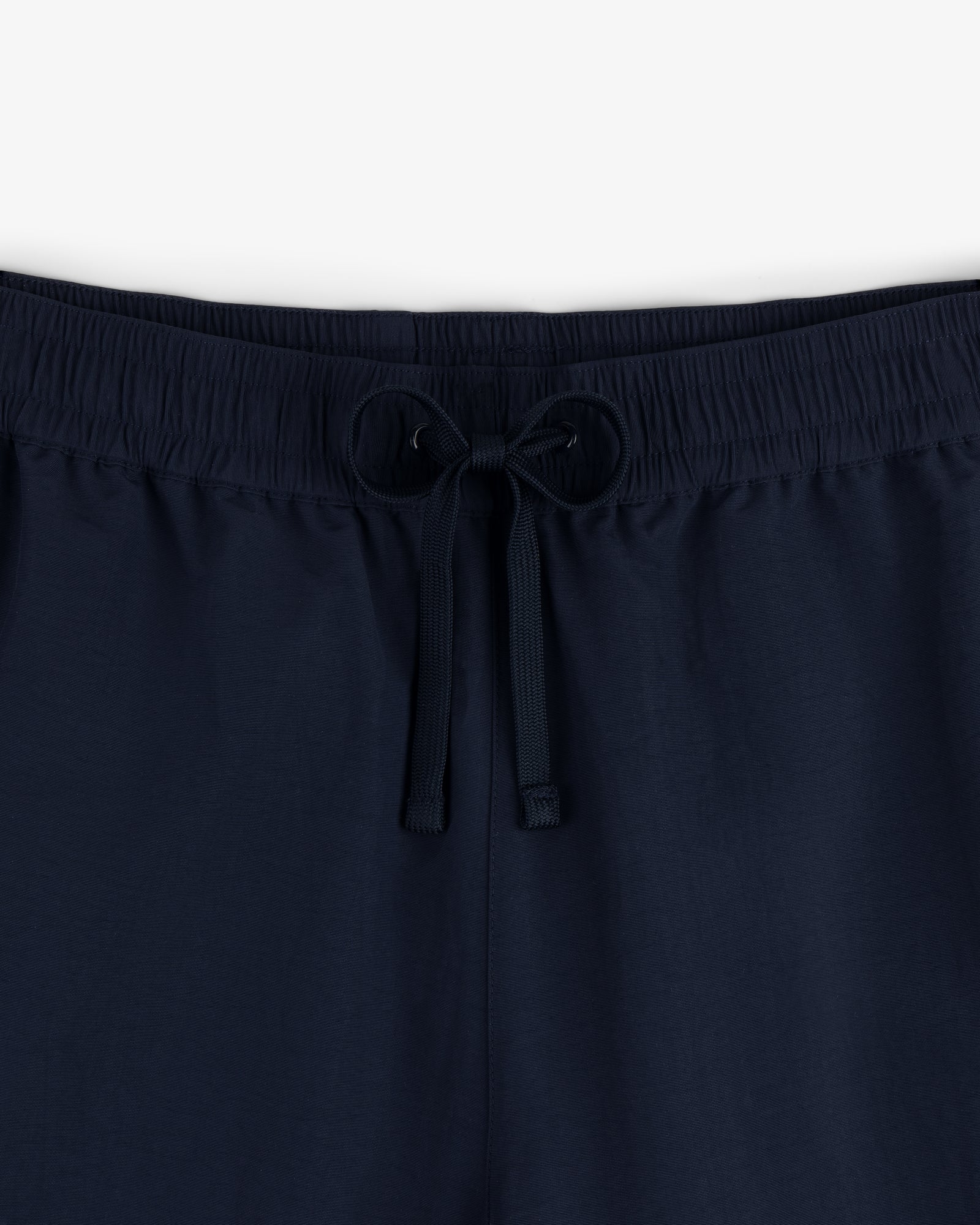 Close-up of Crest Nylon Track Pant in navy blue with an elastic waistband and drawstring, shown against a plain background.