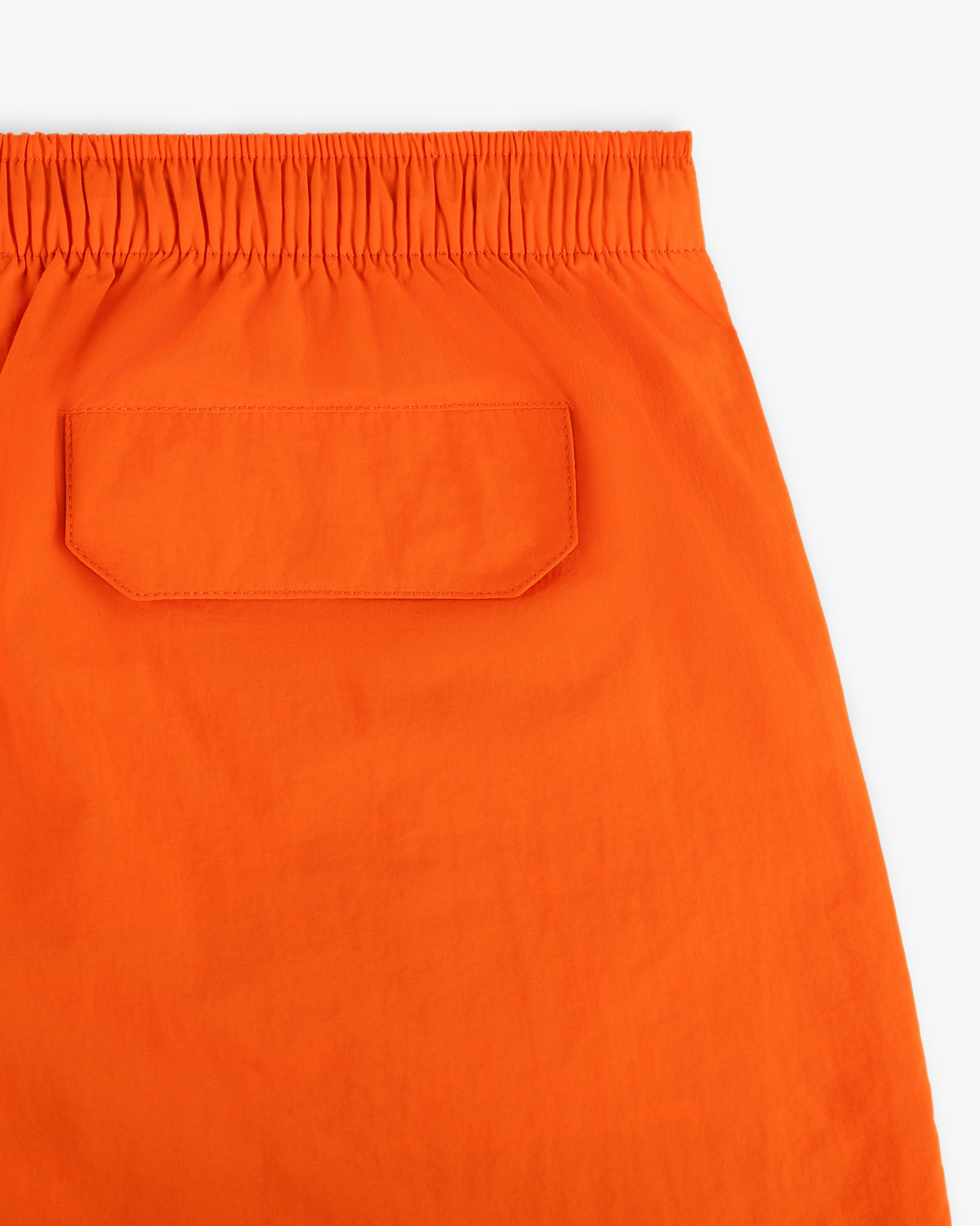 Close-up of the back of Logo Swim Short in orange, featuring an elastic waistband and single back pocket.