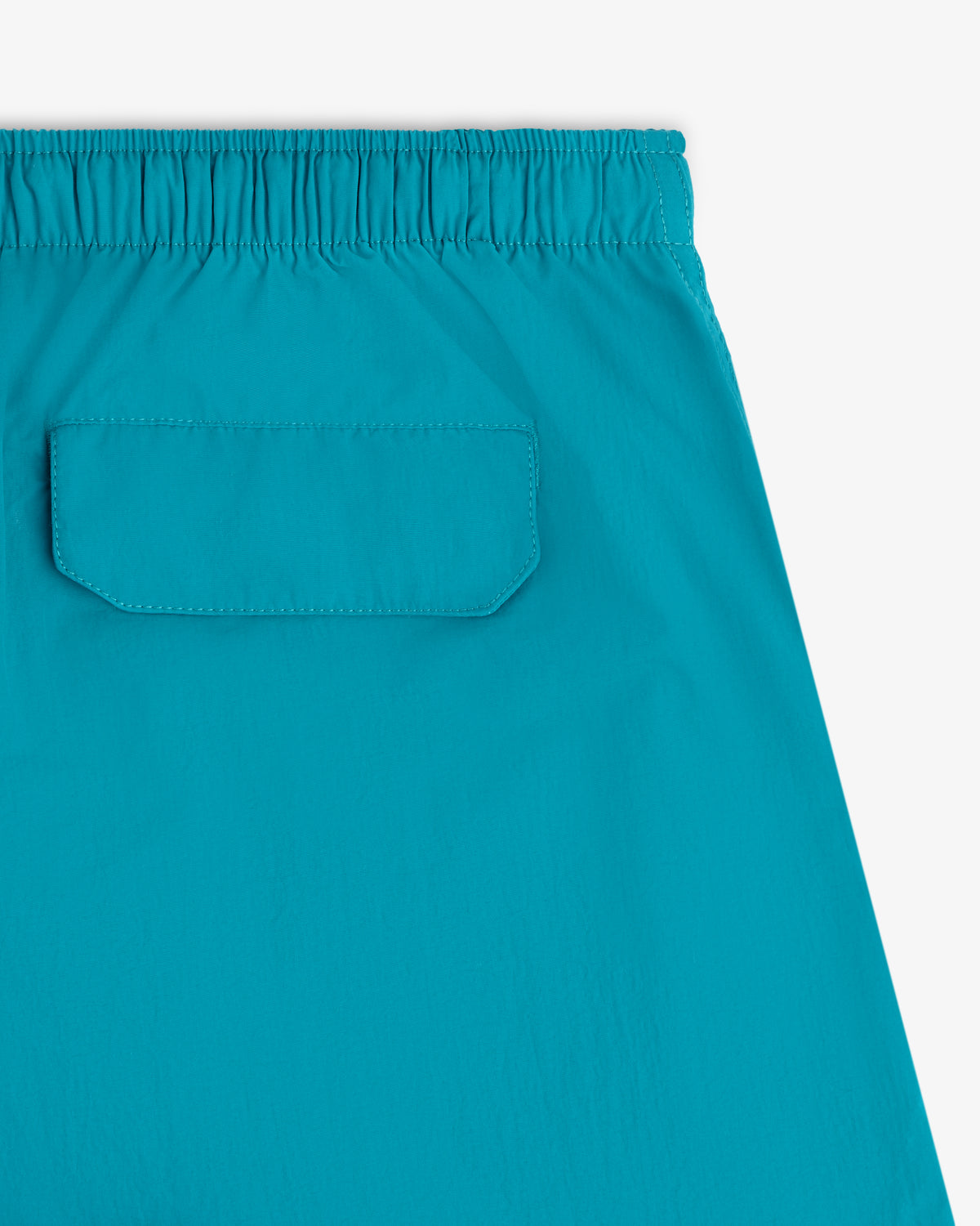 Close-up of Logo Swim Short in blue with elastic waistband and a back pocket with flap.