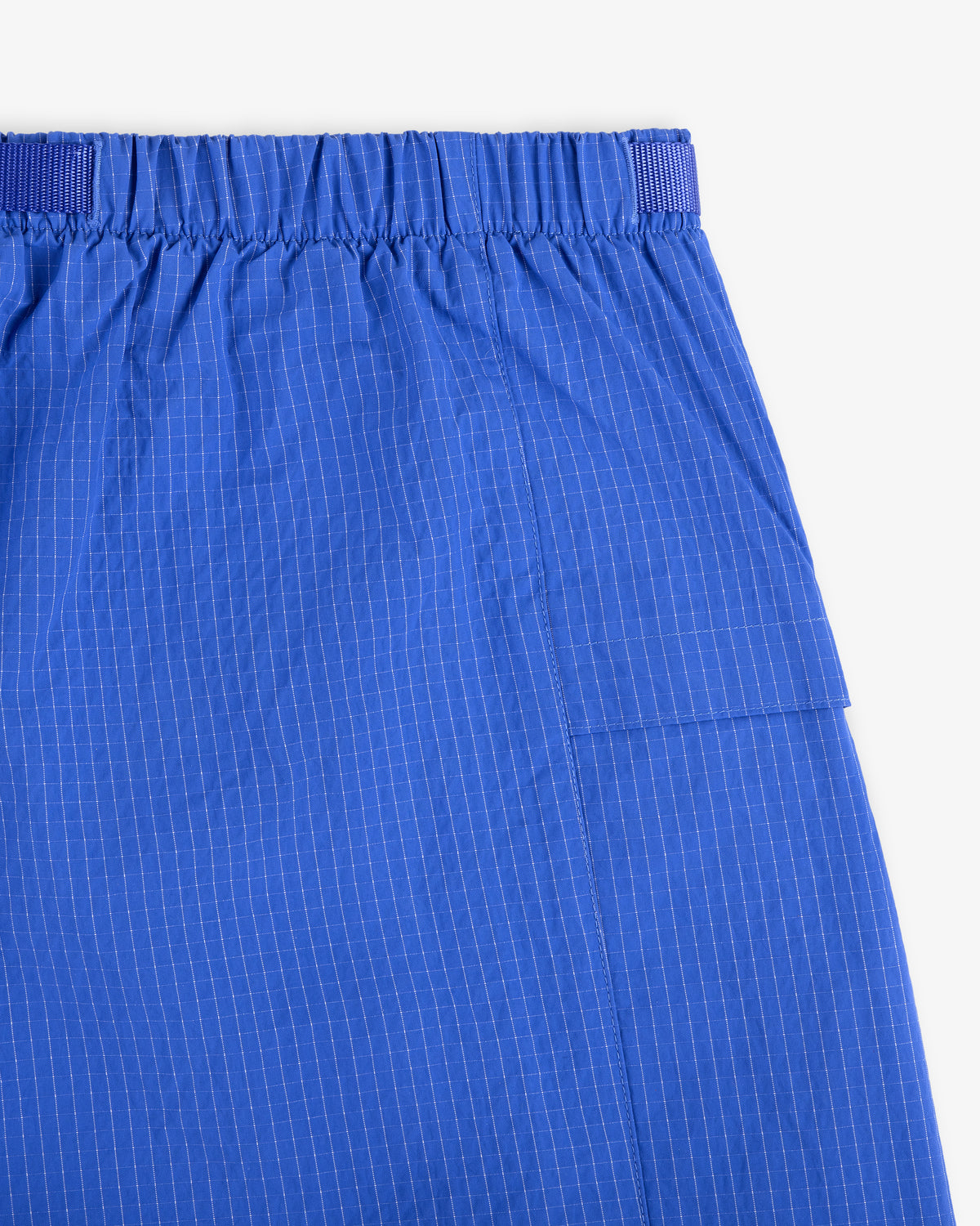 Close-up of Ripstop Nylon Wave Short in blue with white pinstripes, elastic waistband, and side pocket on white background.