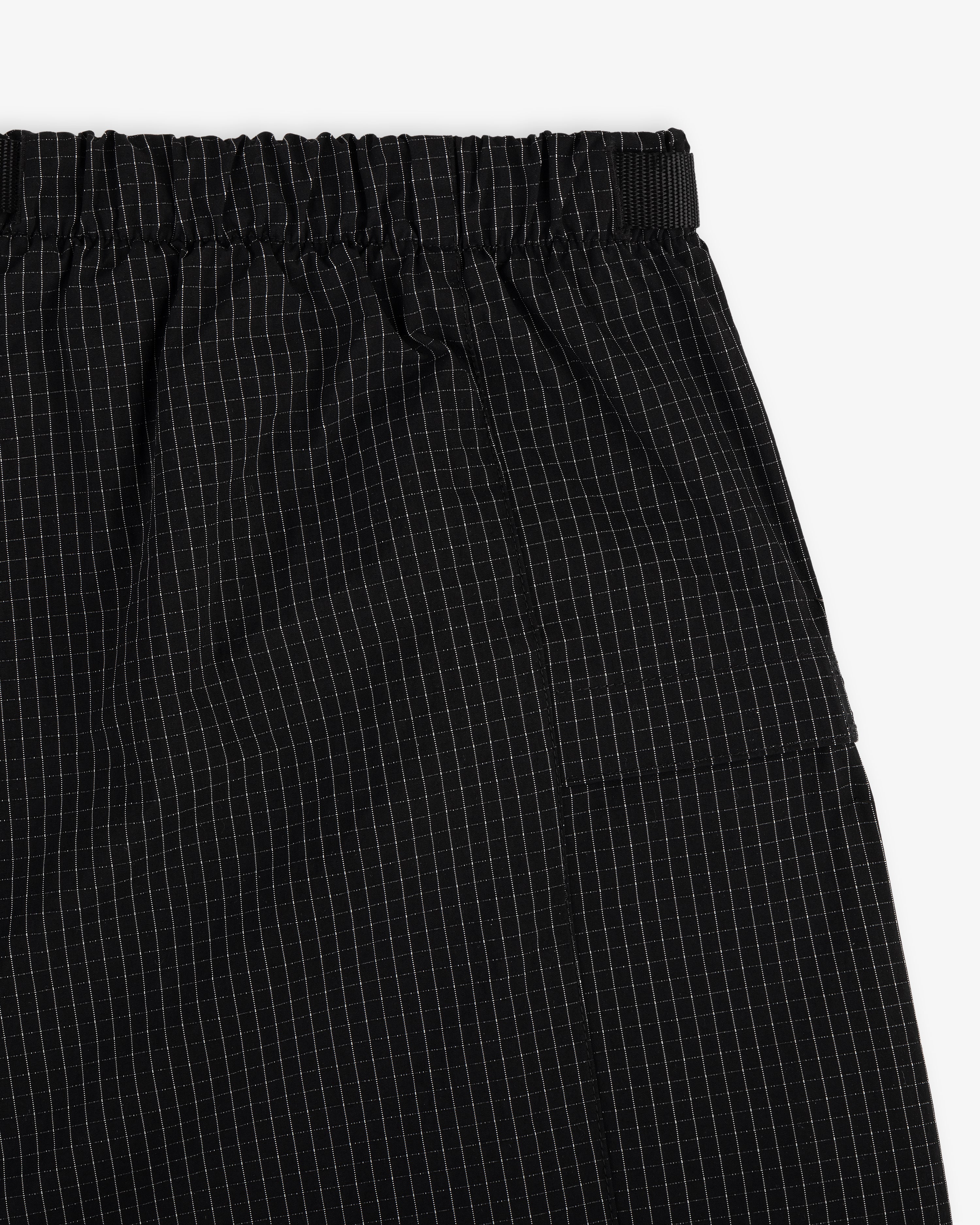 Close-up of Ripstop Nylon Wave Short in black with elastic waistband and white grid pattern.