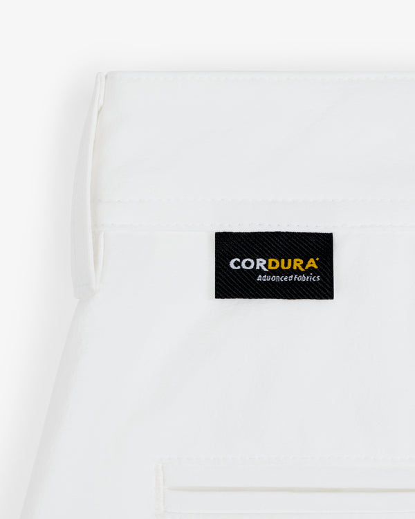A white ALD Golf Cordura Double Pleated Short with a black CORDURA Advanced Fabrics label sewn near the seam.