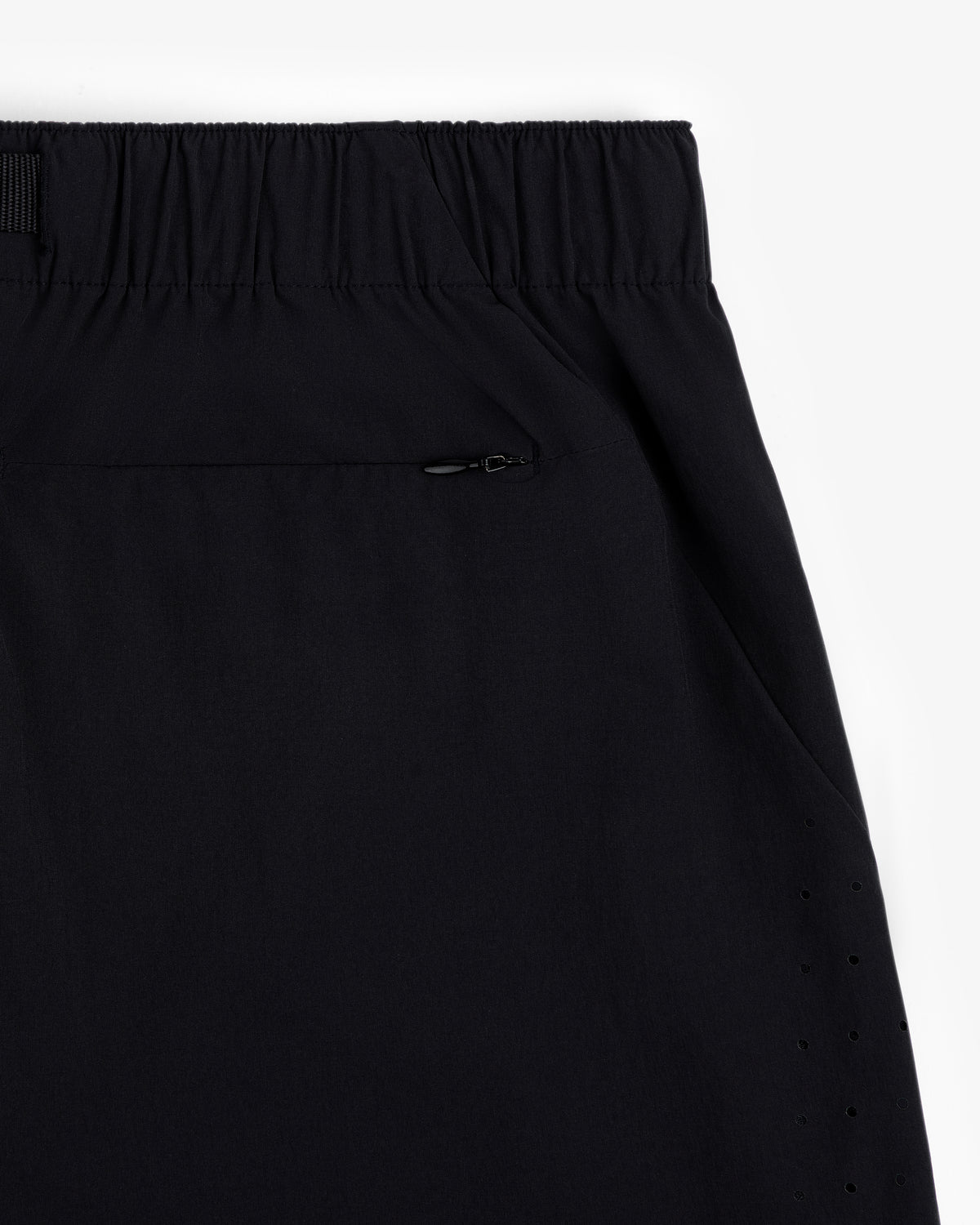 Close-up of ALD Golf Performance Short in black with elastic waistband, zippered pocket, and side ventilation holes.
