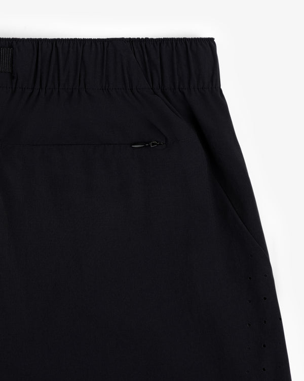Close-up of ALD Golf Performance Short in black with elastic waistband, zippered pocket, and side ventilation holes.