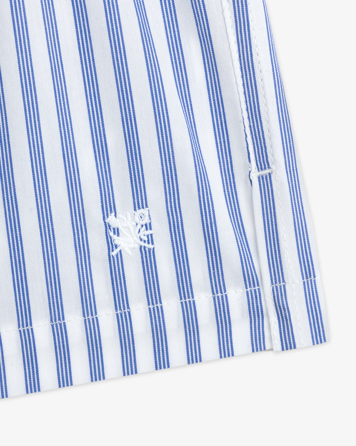 Close-up of Striped Boxer Short in blue and white with a small white embroidered crab near the hem.