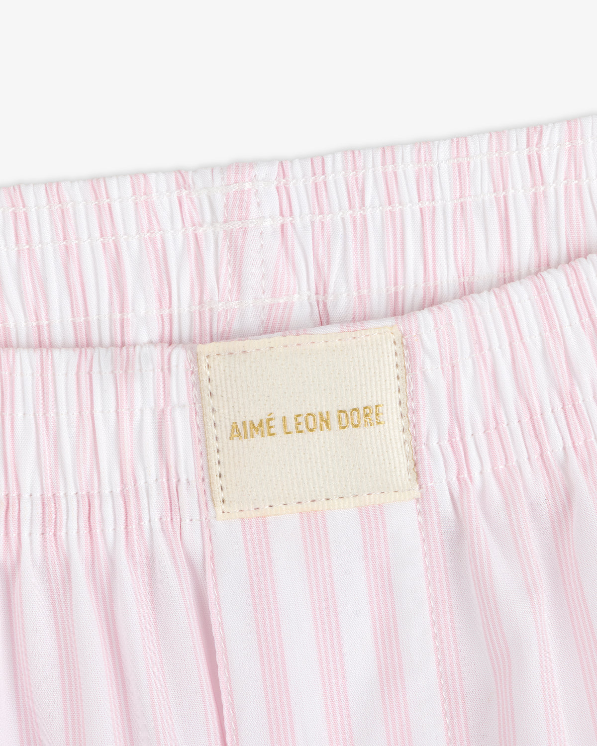 Close-up of Striped Boxer Short featuring pink and white stripes and an AIMÉ LEON DORE label on the waistband.
