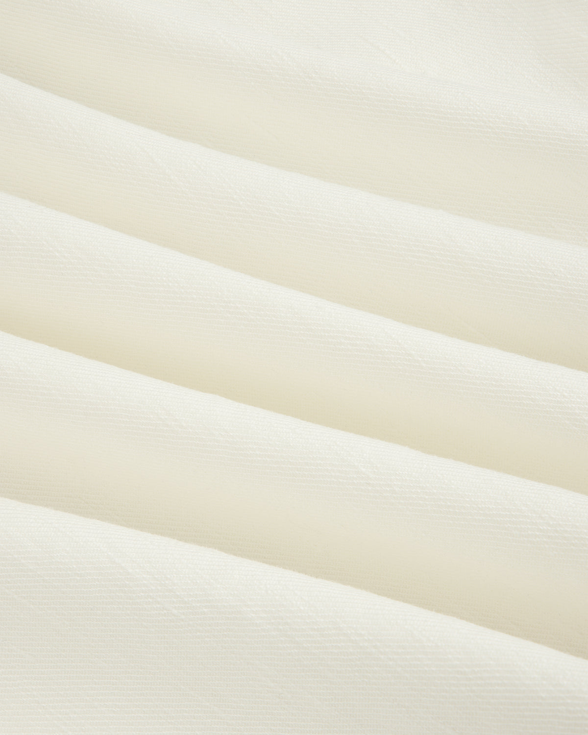 Close-up of Pleated Linen Blend Bermuda Short in white, featuring soft fabric with gentle horizontal folds.