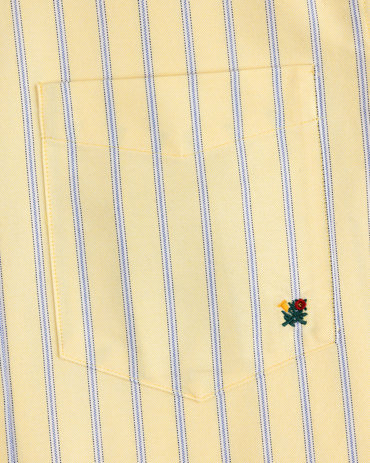 Yarn Dyed Striped Crest Shirt: yellow with blue stripes, pocket, and a small red-yellow embroidered flower at the bottom right.