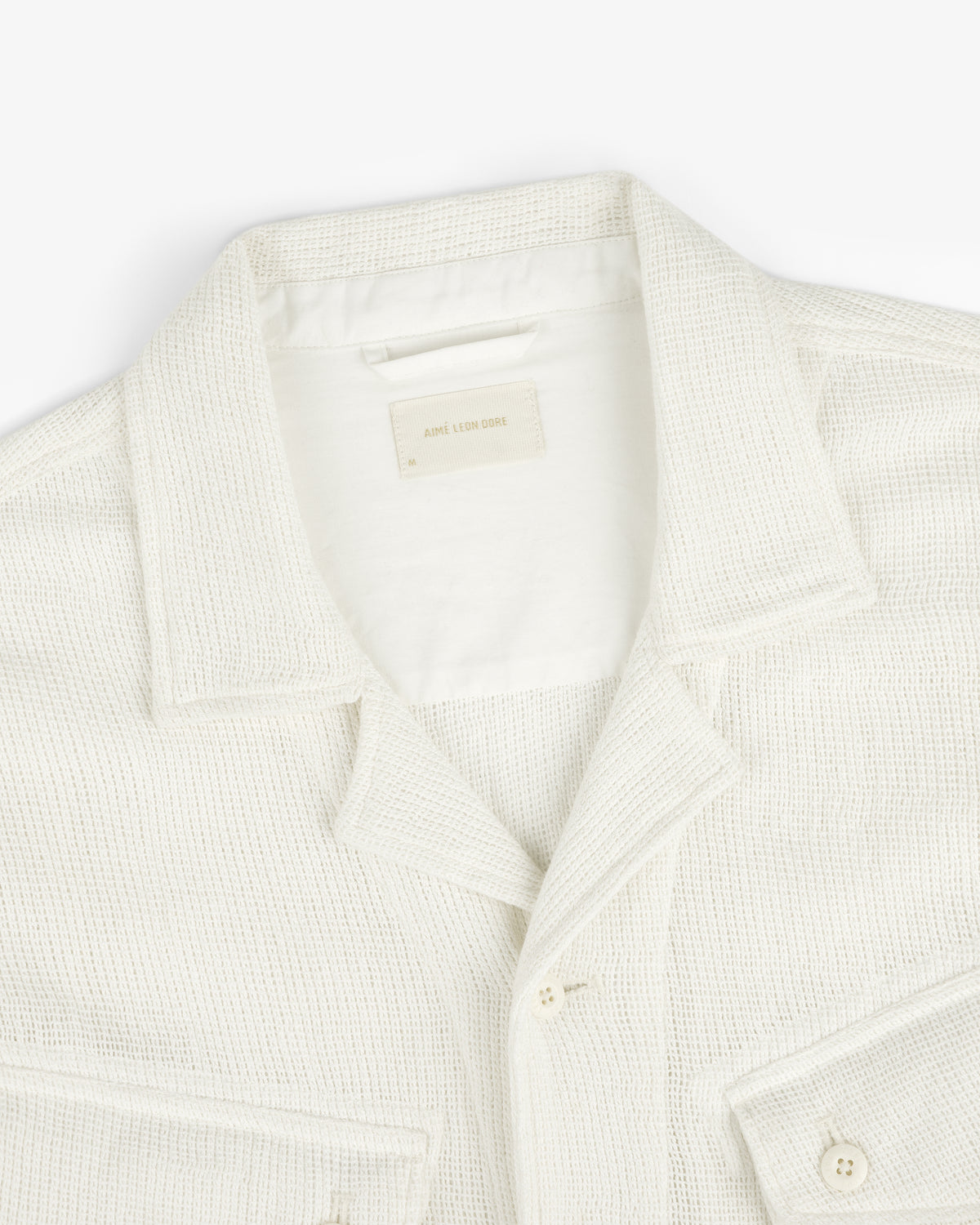 Cream-colored Mesh Jungle Shirt with collar, buttons, and front pockets on a white background.