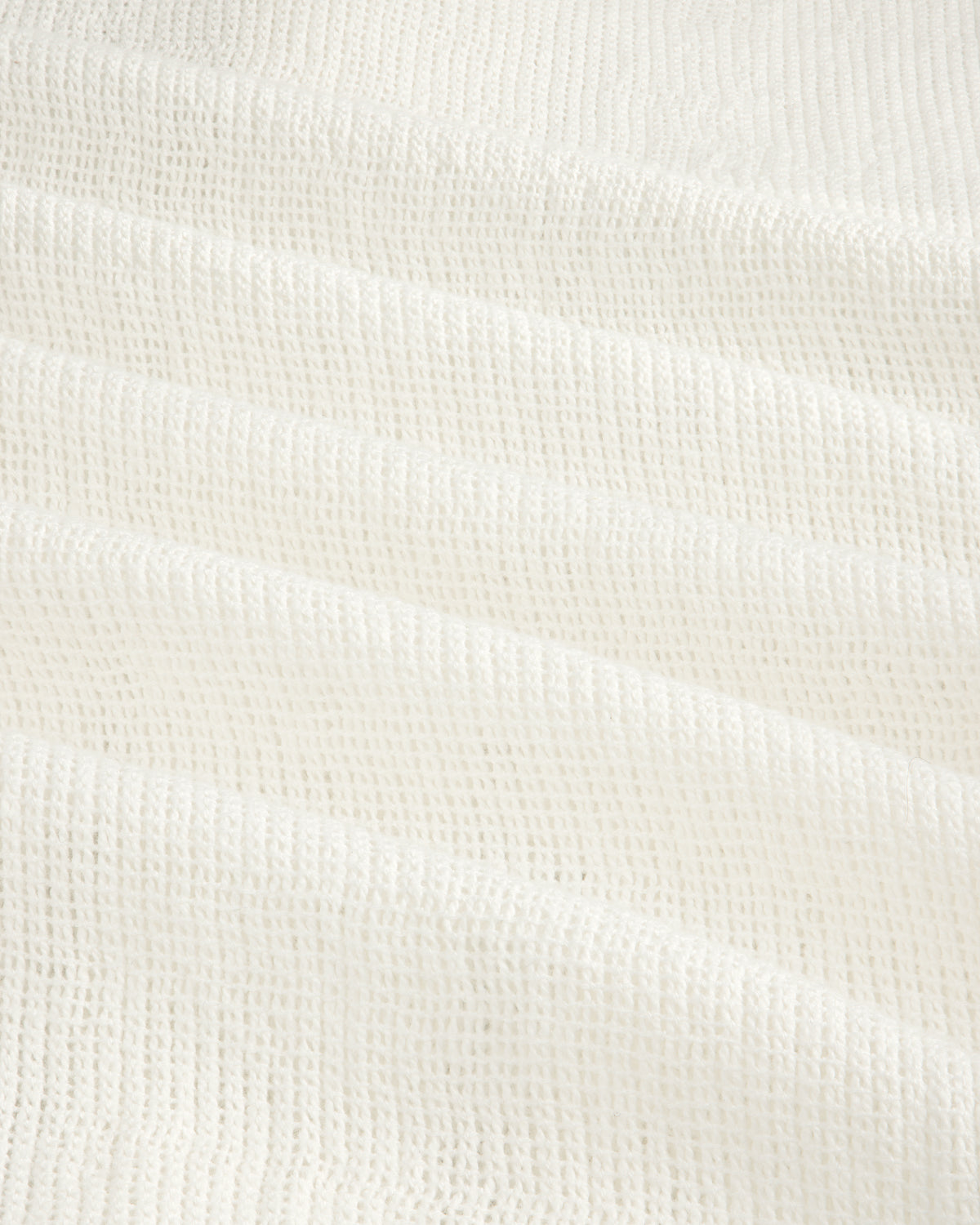 Close-up of the Mesh Jungle Shirt's white waffle-textured fabric with soft, grid-like ridges.