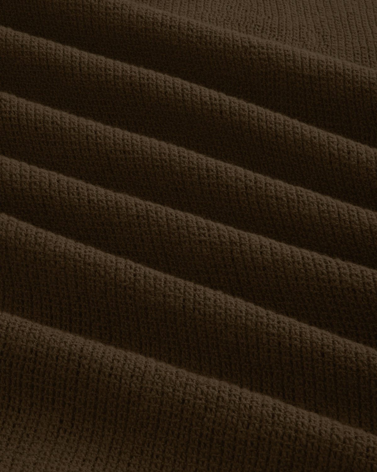 Close-up of the Mesh Jungle Shirt's brown, ribbed knit fabric with textured, evenly spaced horizontal folds.